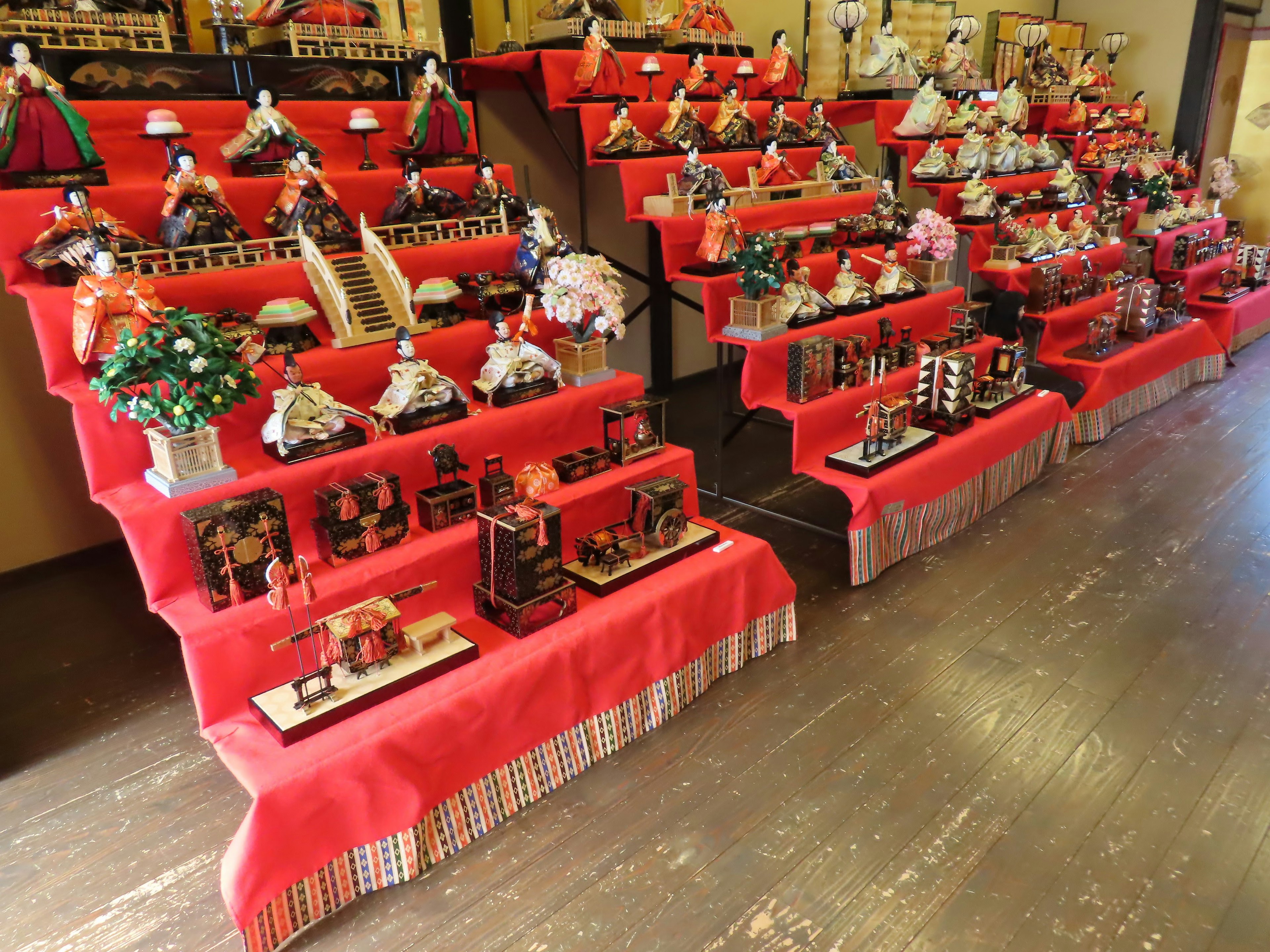 Poupées hina traditionnelles et décorations exposées sur des nappes rouges