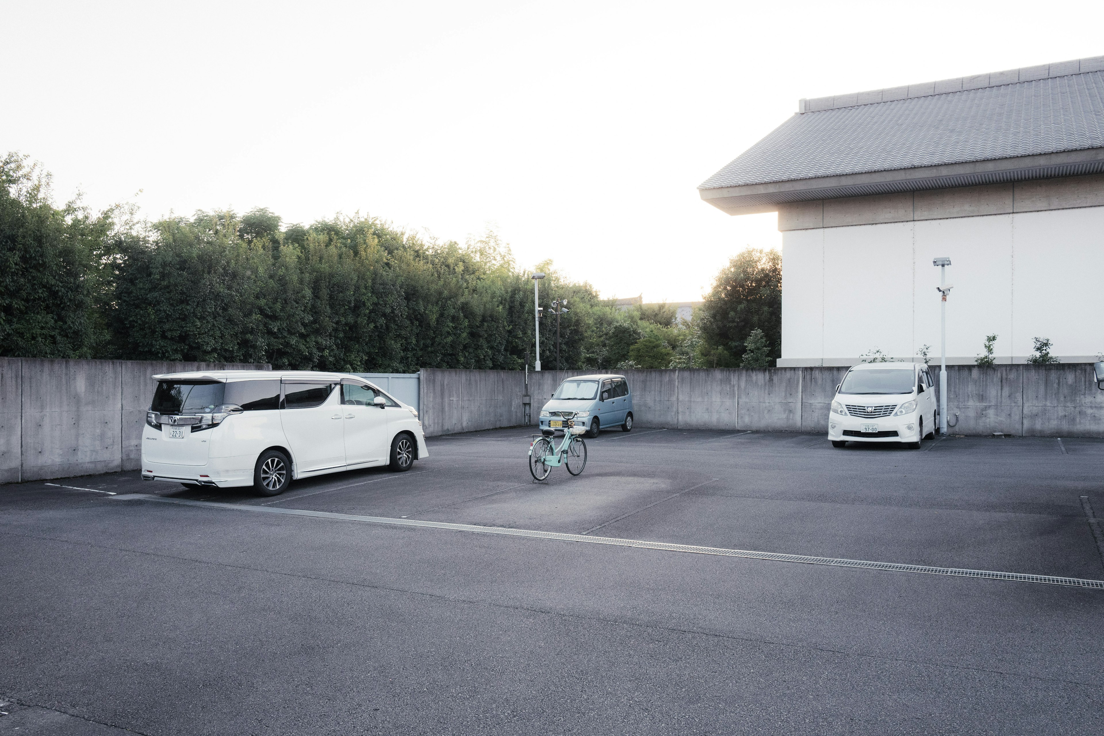 A parking lot featuring several parked cars and a bicycle