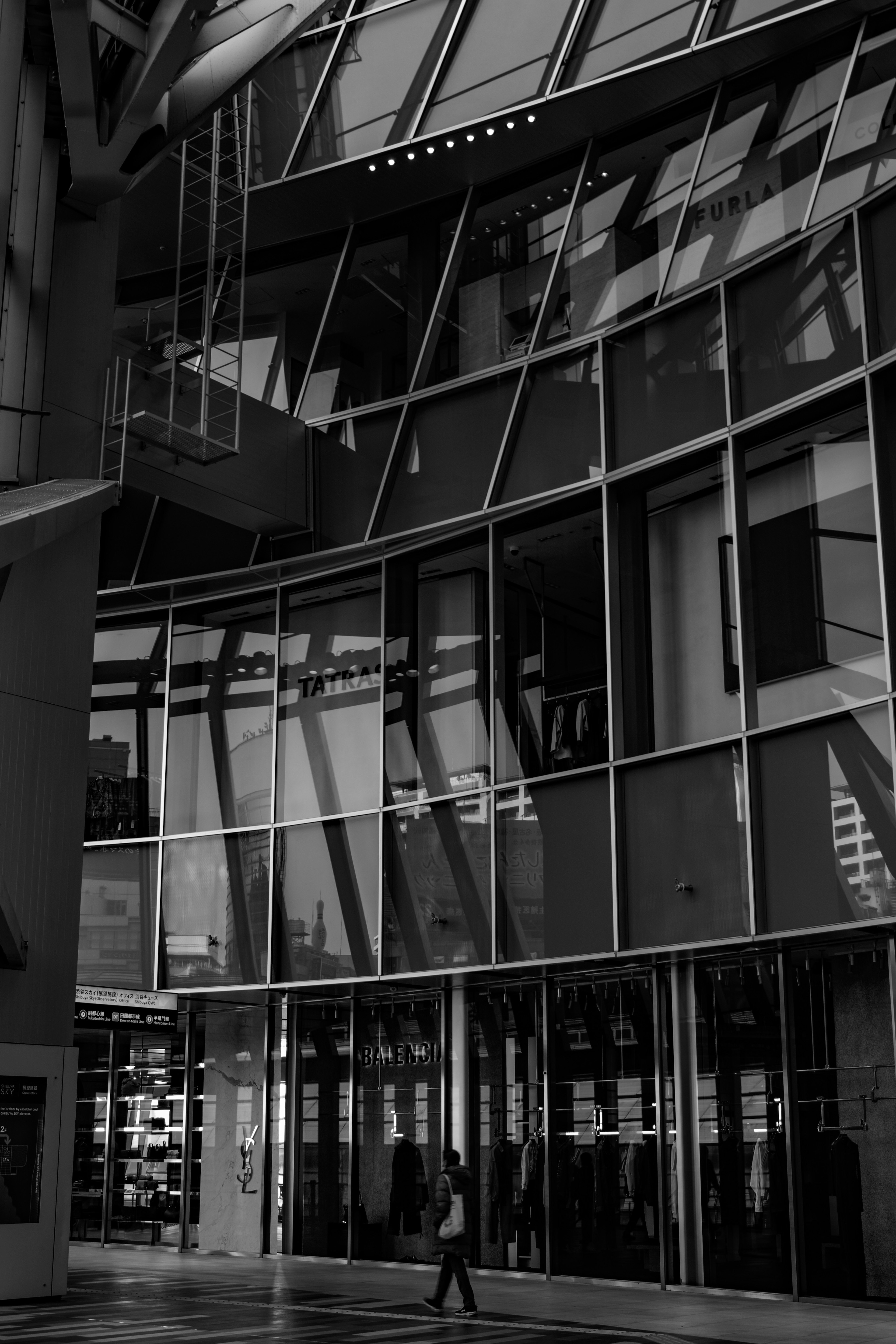 Entrée d'un bâtiment moderne avec façade en verre et ombres