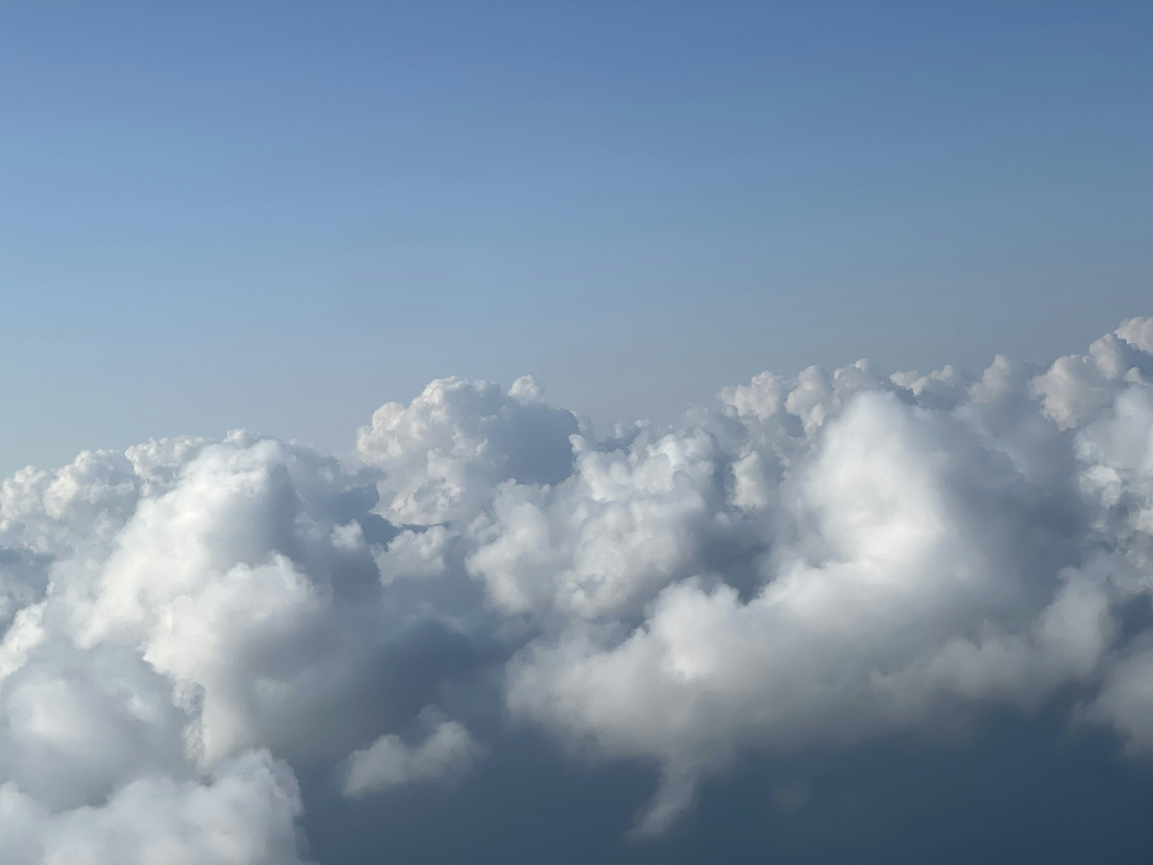 Pemandangan awan putih berbulu di langit biru