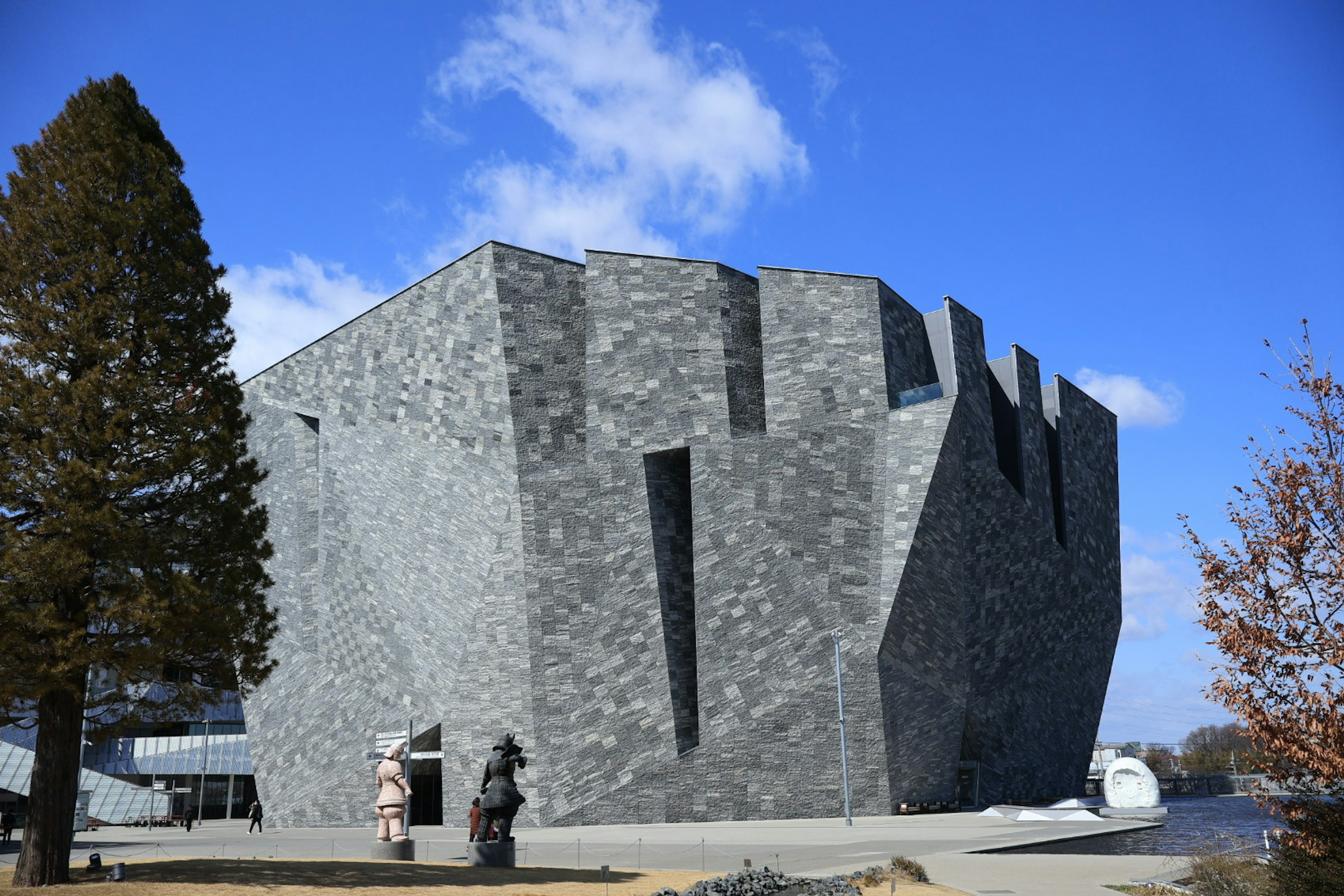 Bangunan batu modern dengan desain sudut di bawah langit biru