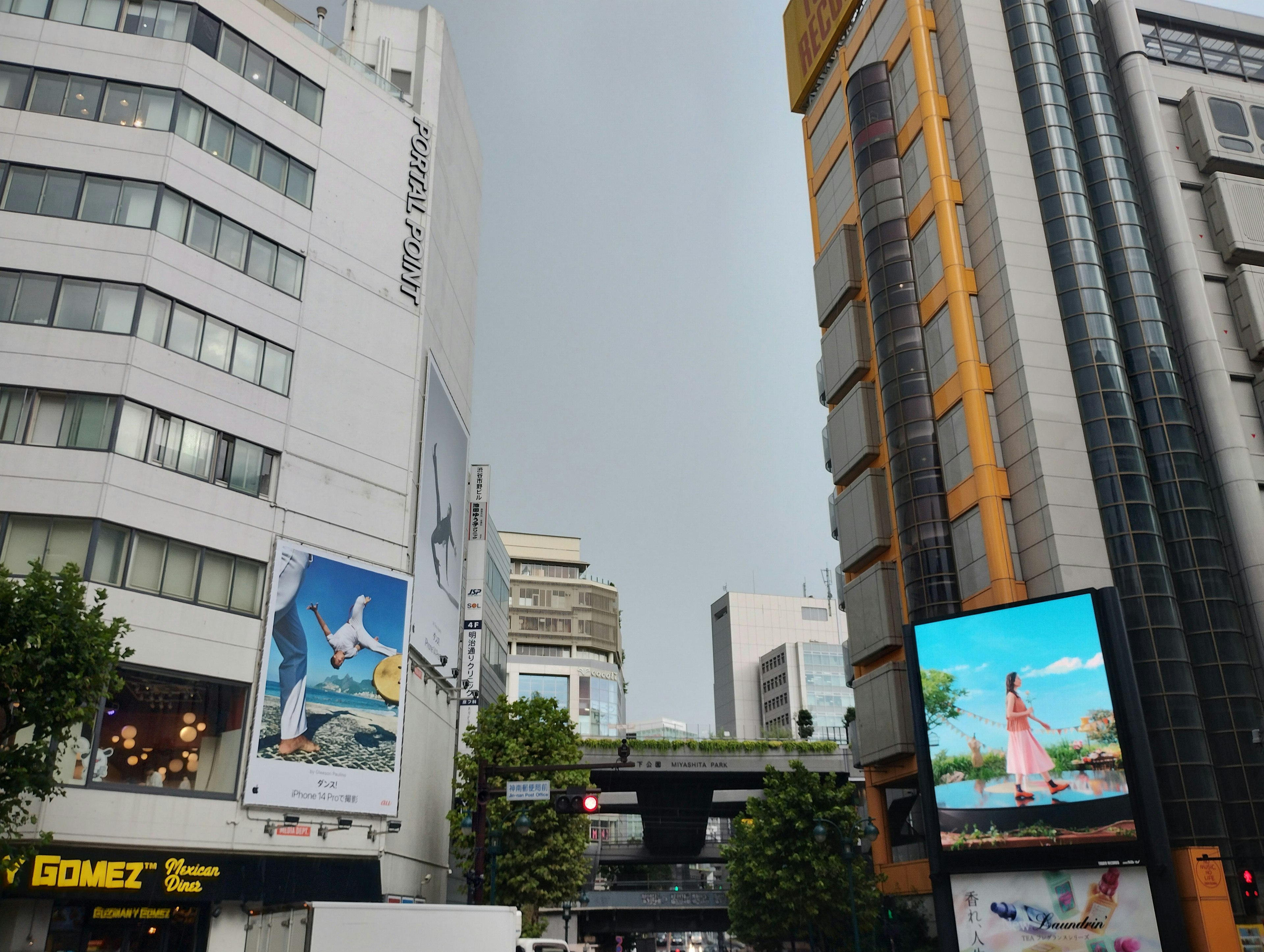 都市の風景に高層ビルと広告が見える