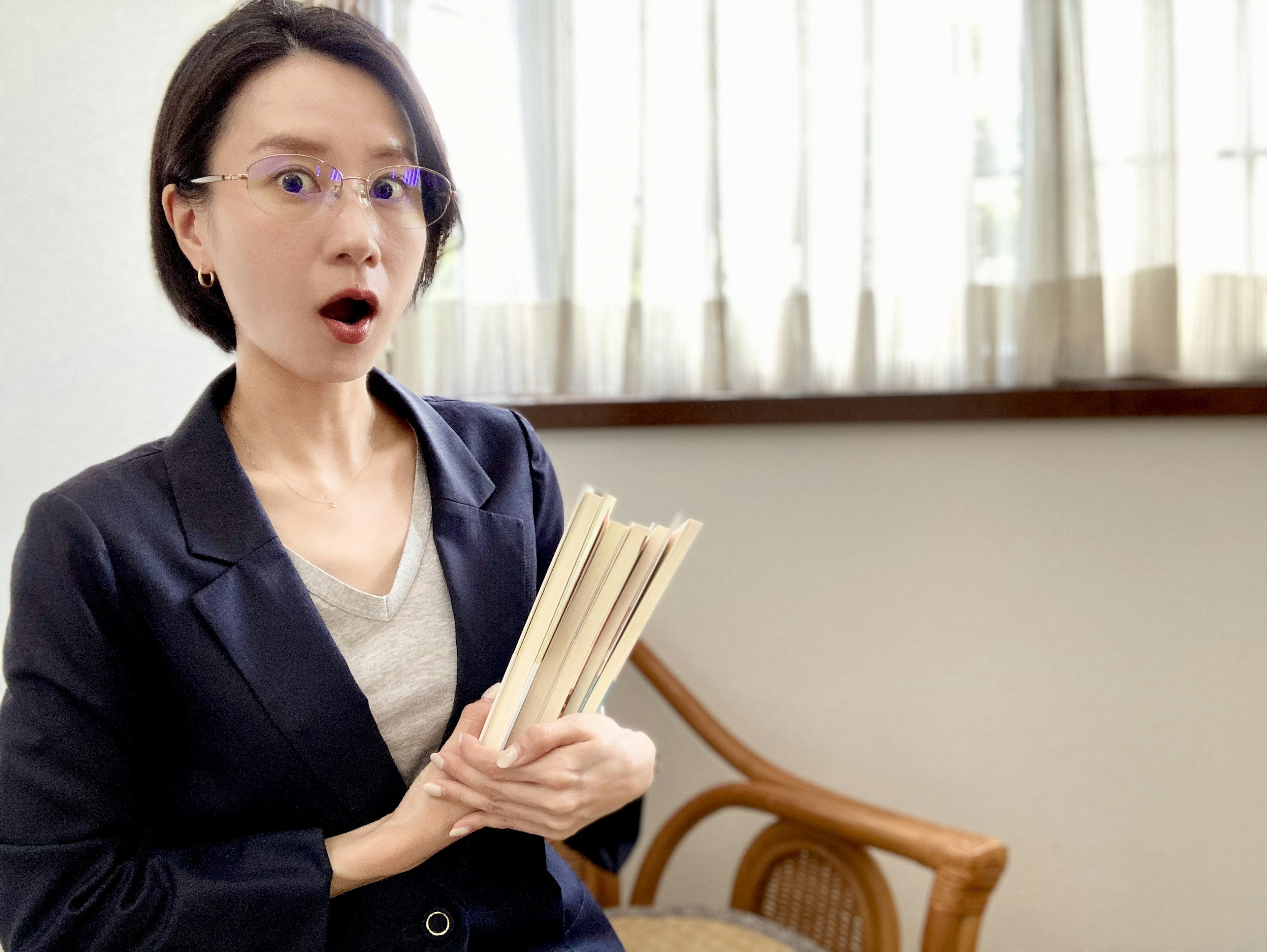 A surprised woman holding a book with a shocked expression