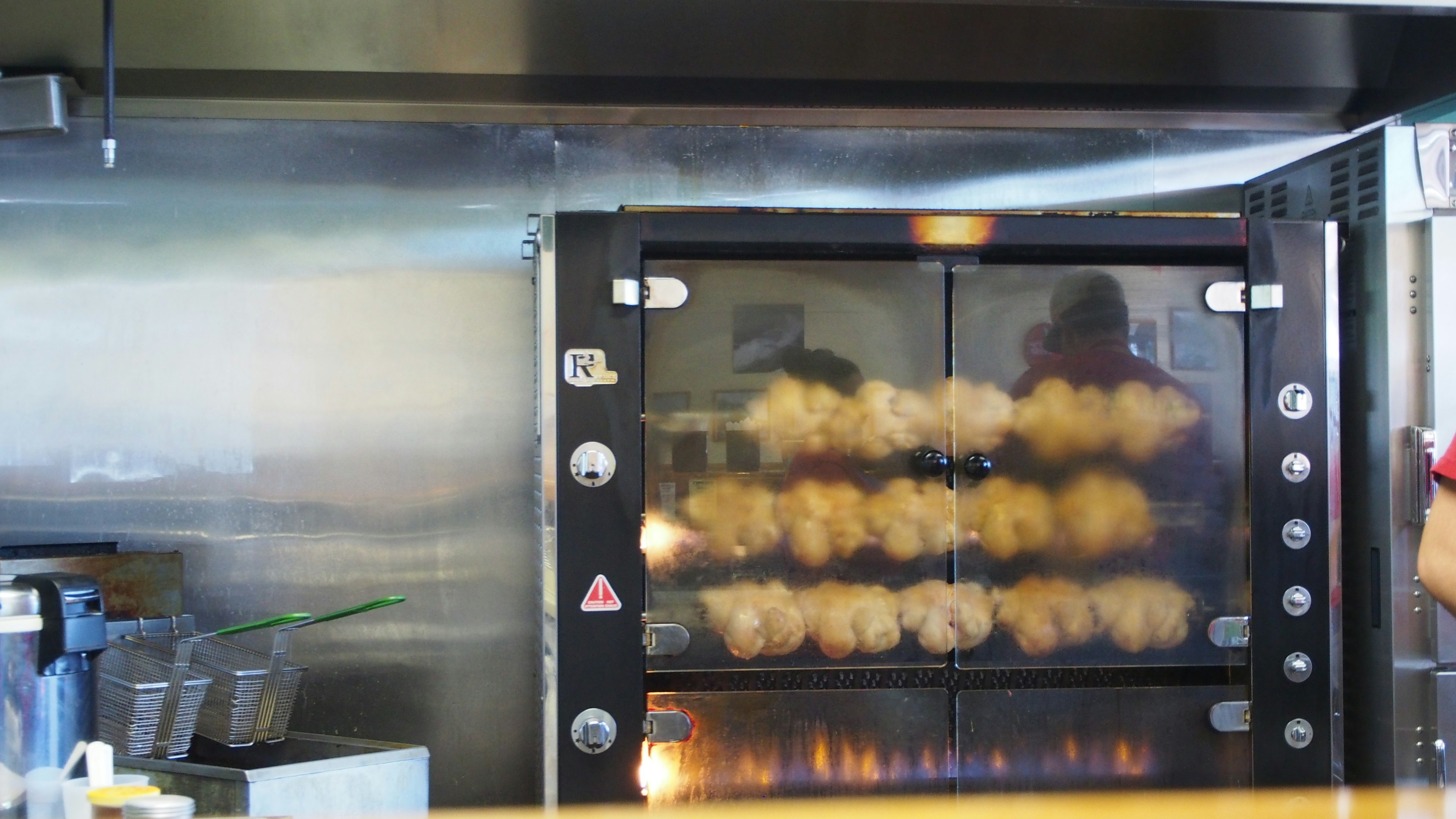 Vue d'une machine de cuisson avec des brochettes de poulet grillées