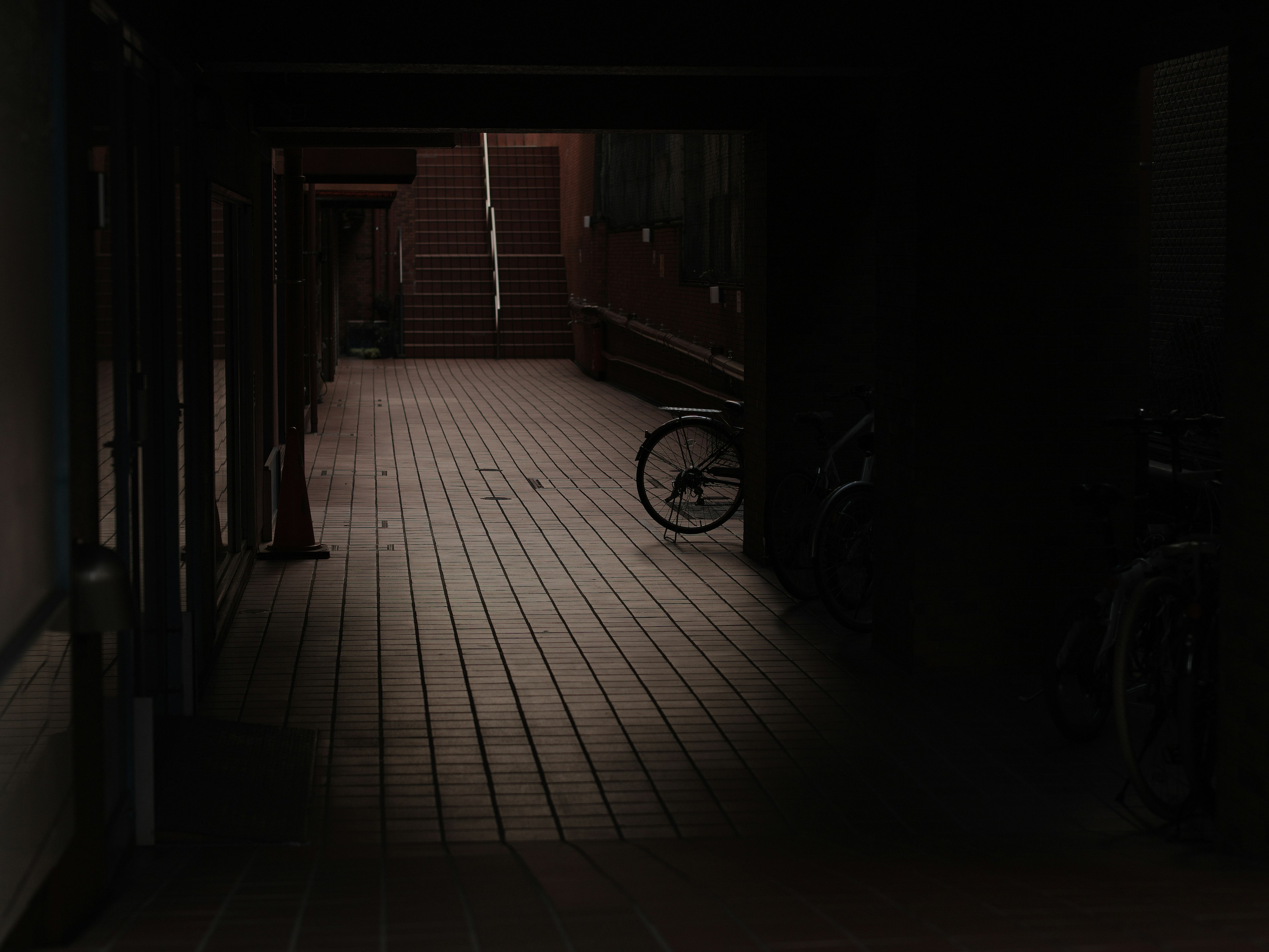 Dimly lit corridor with a bicycle on wooden floor