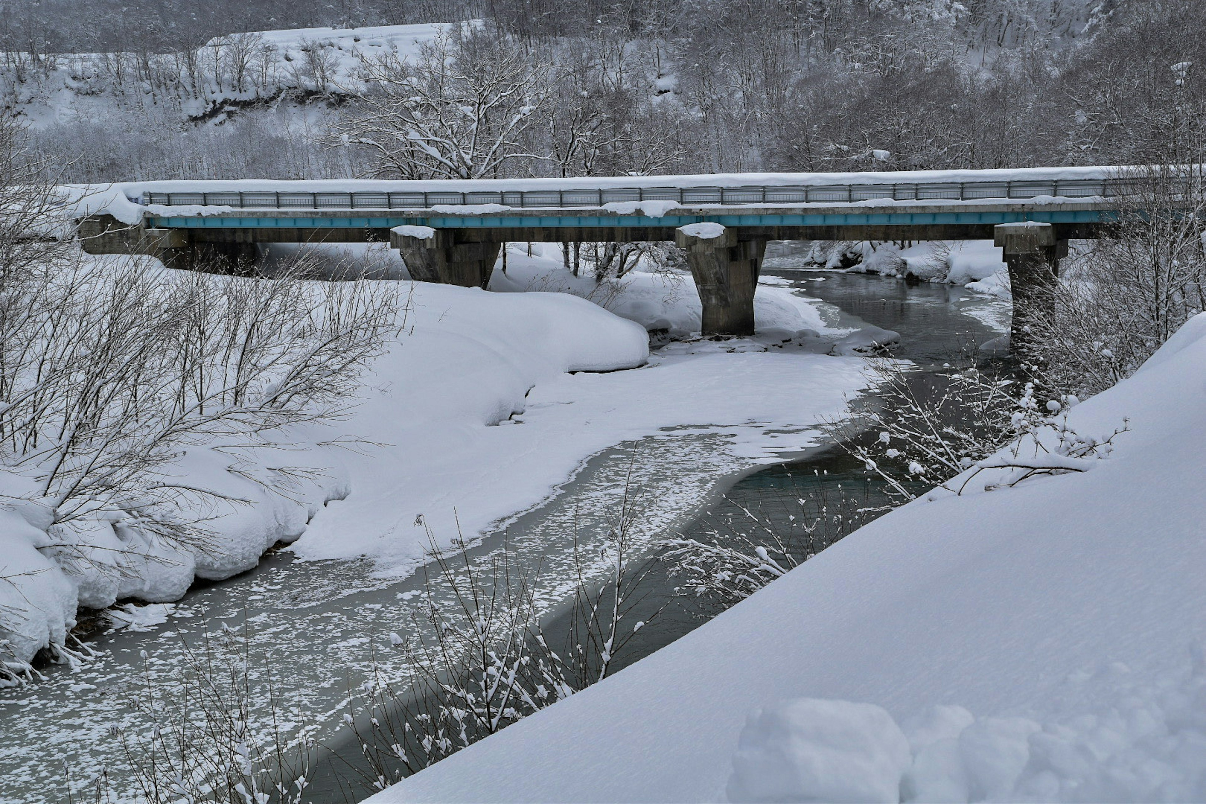 雪に覆われた川と橋の風景