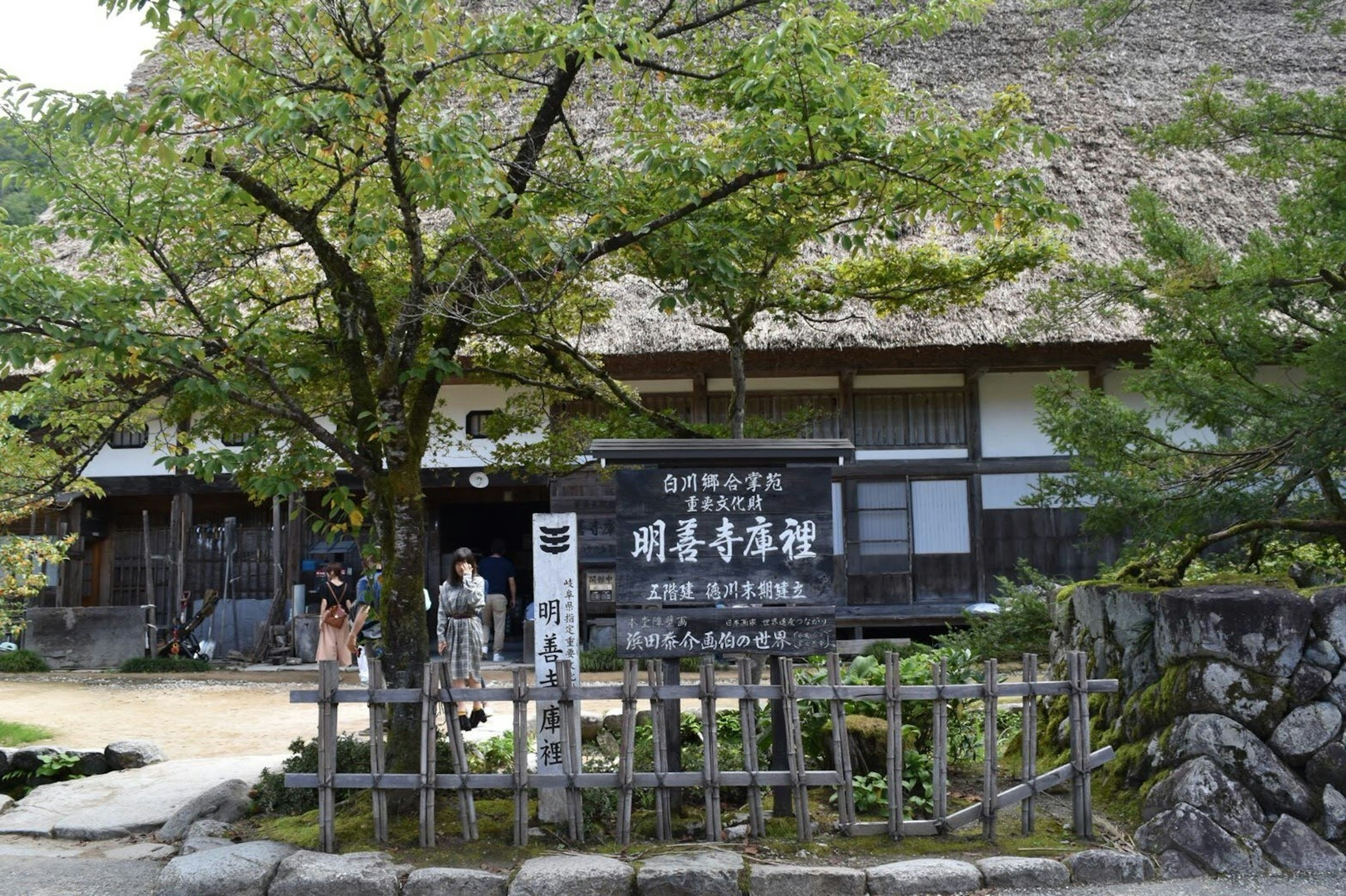 Traditional Japanese house with thatched roof and garden view wooden fence