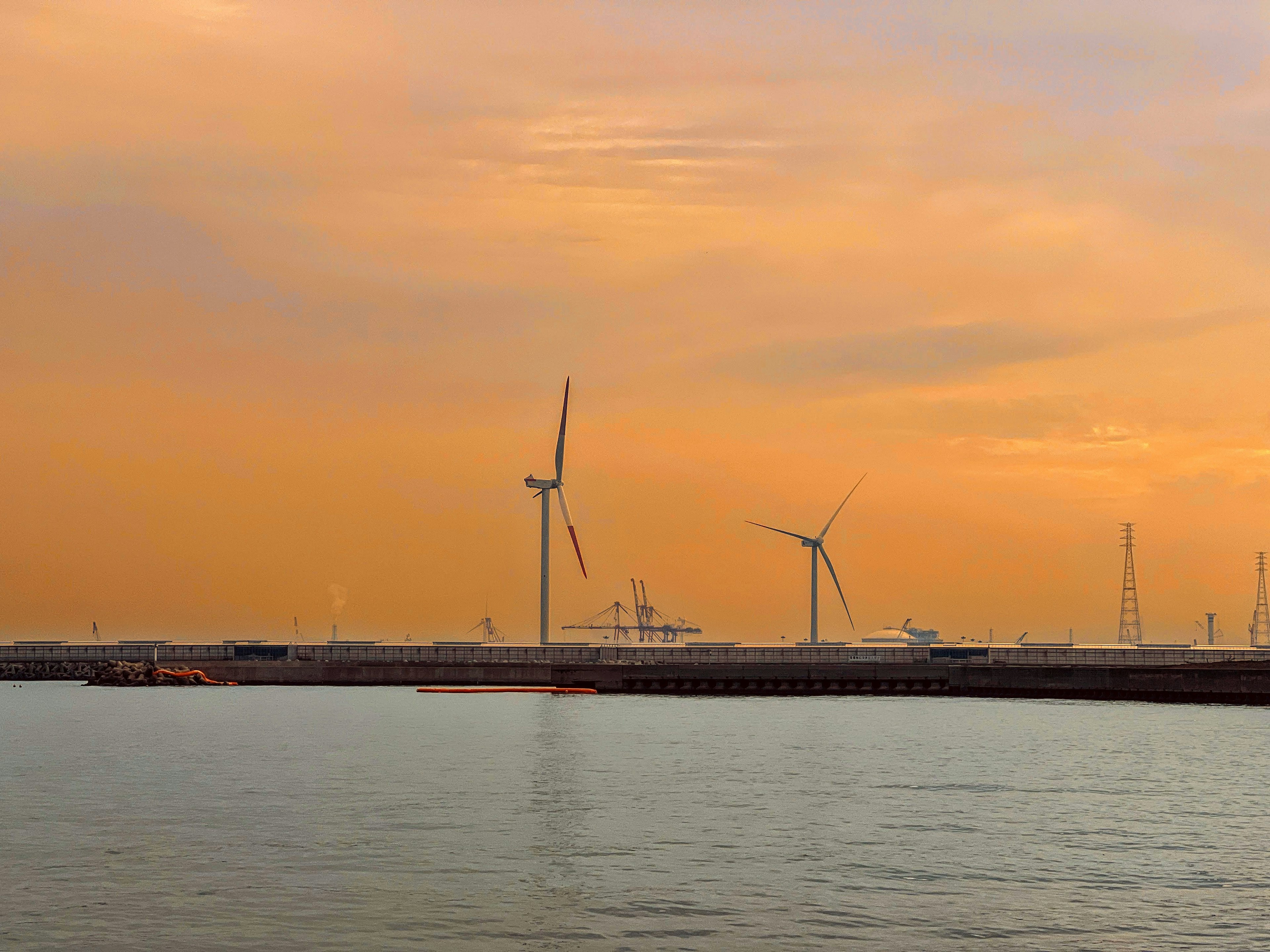 Sonnenuntergangshimmel mit Windkraftanlagen entlang der Küste