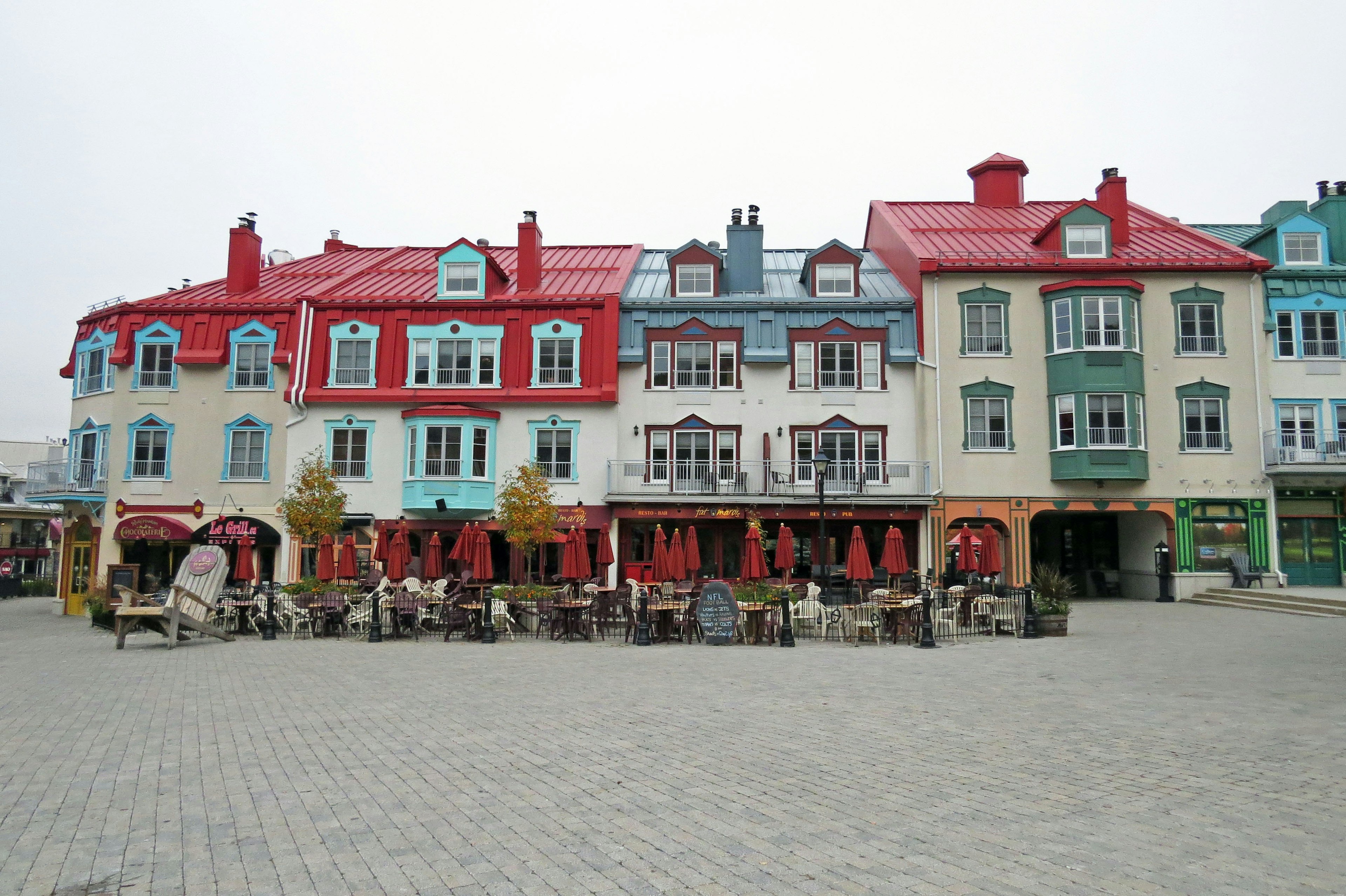 Bunte Gebäude mit roten und blauen Dächern auf einem Platz