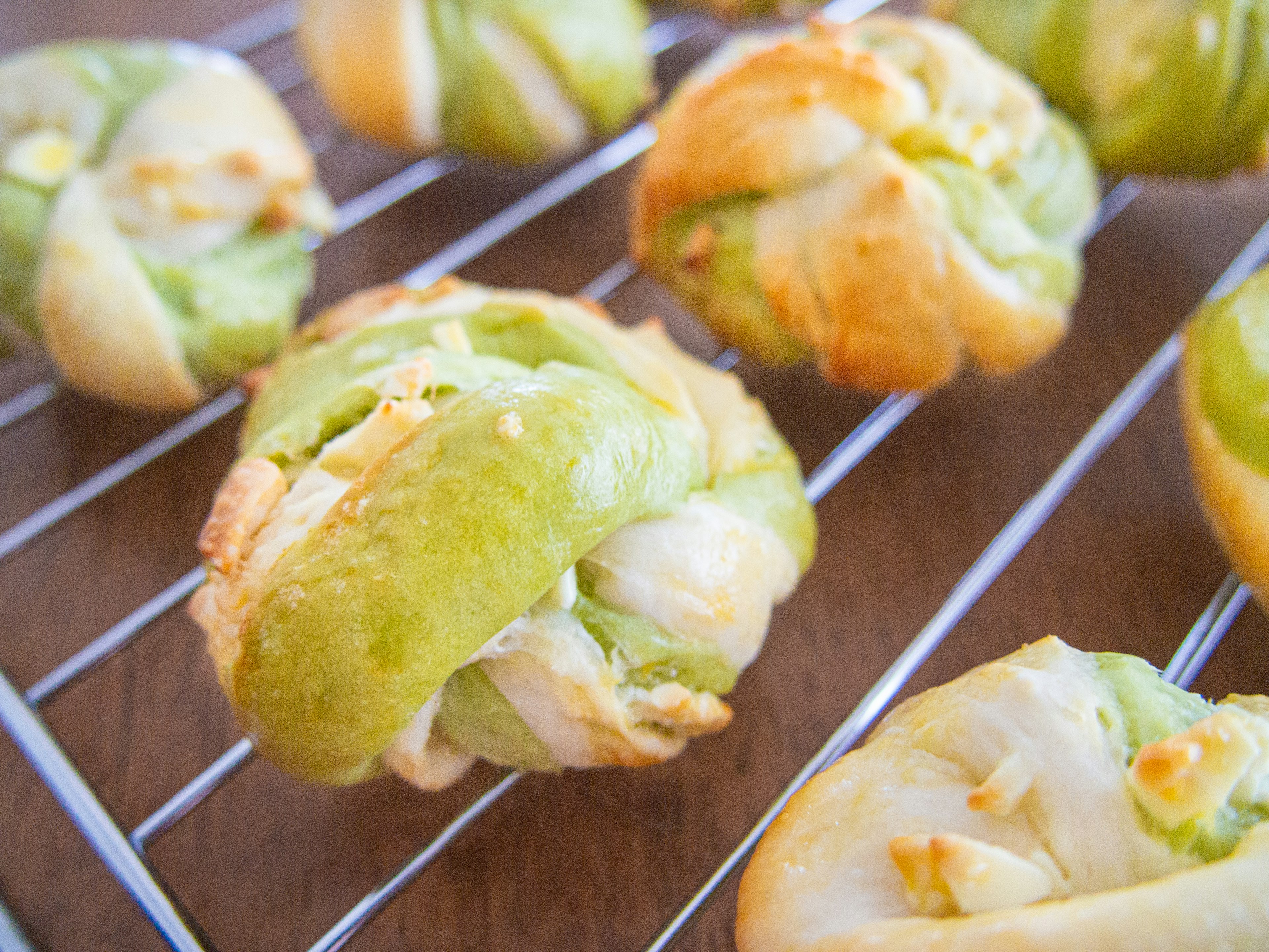 Green dough buns arranged on a cooling rack