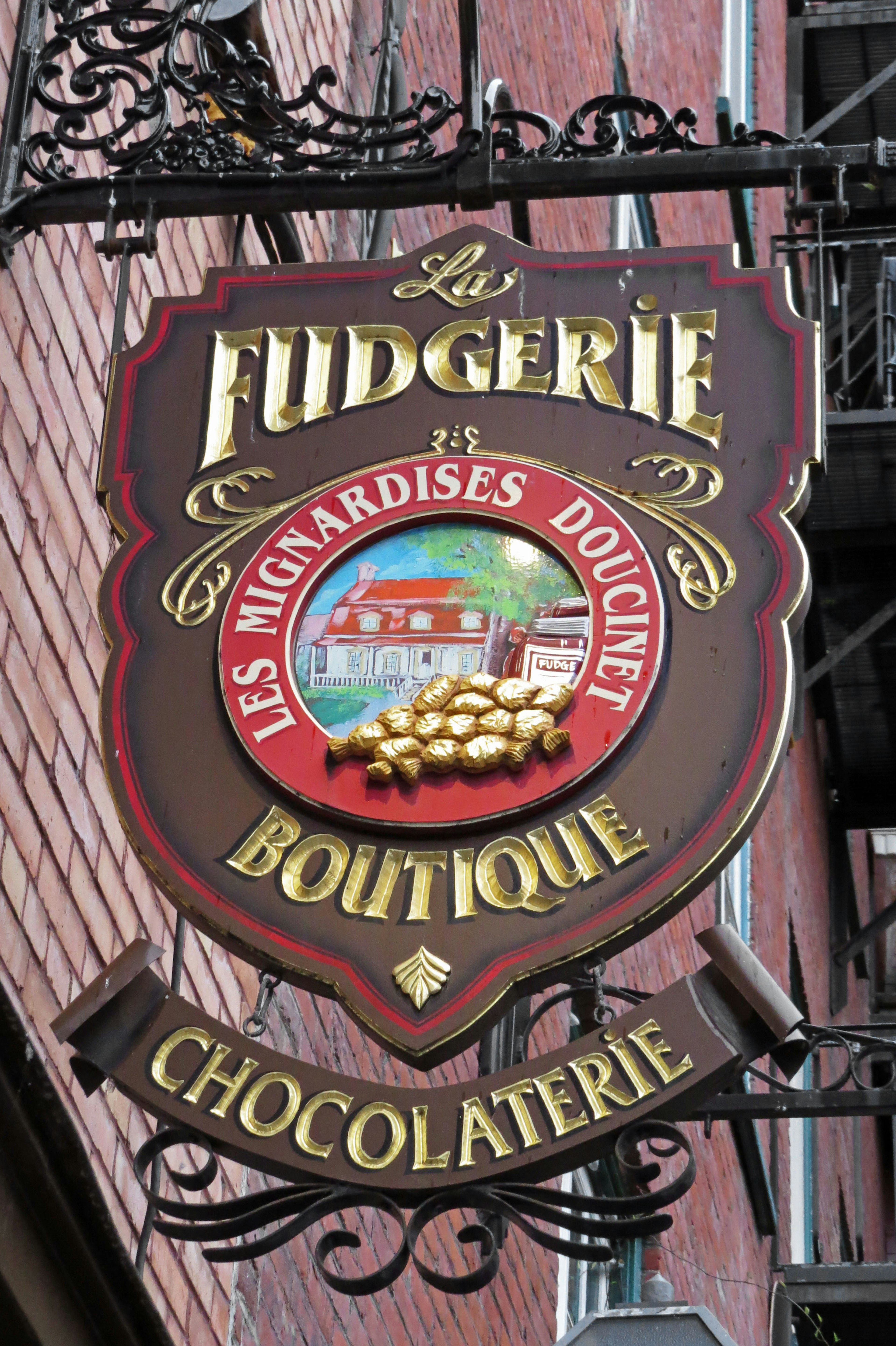 Schild einer französischen Chocolaterie mit einem bunten Logo und dem Namen des Geschäfts