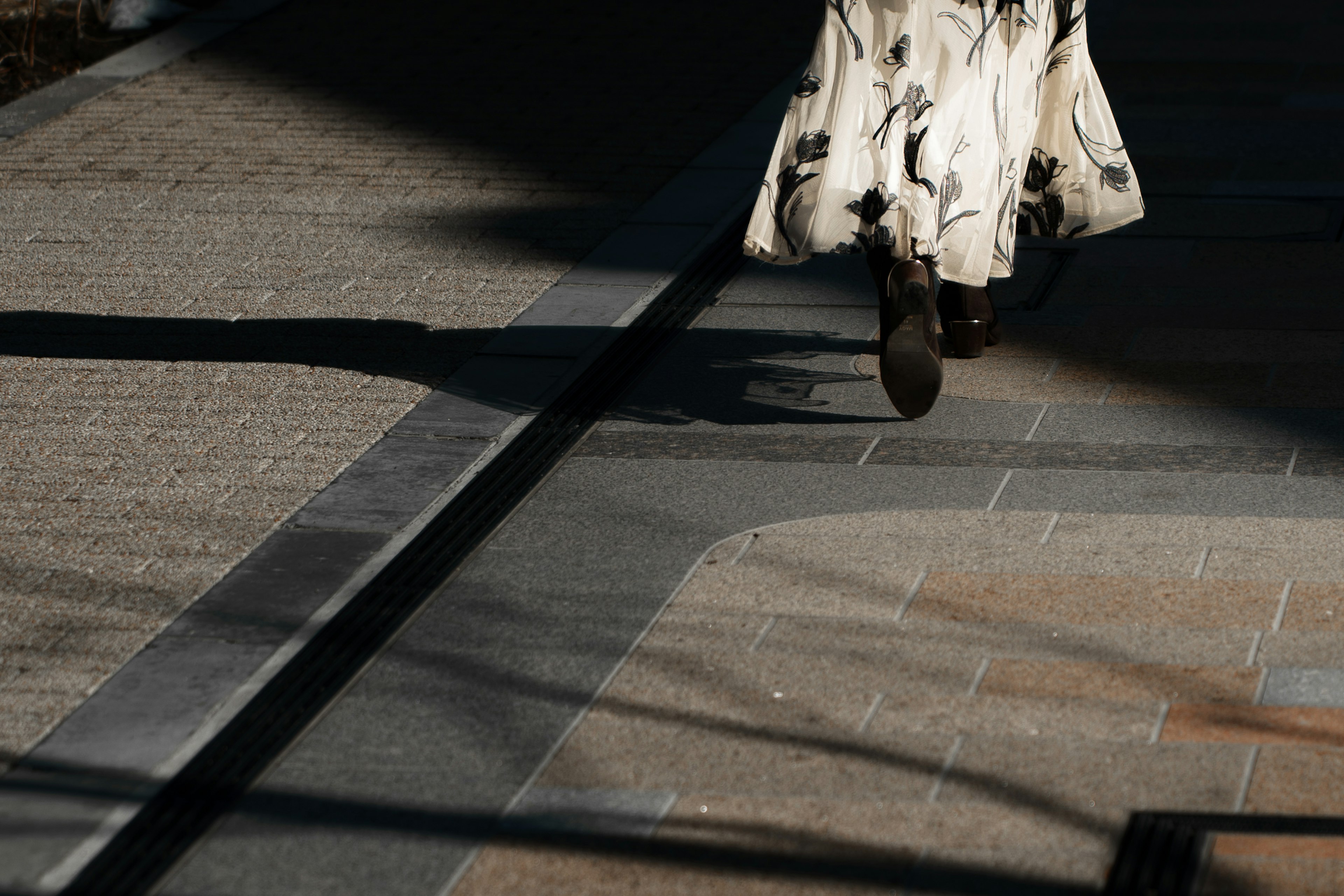 Une femme marchant dans une jupe à fleurs sur un pavé décoré