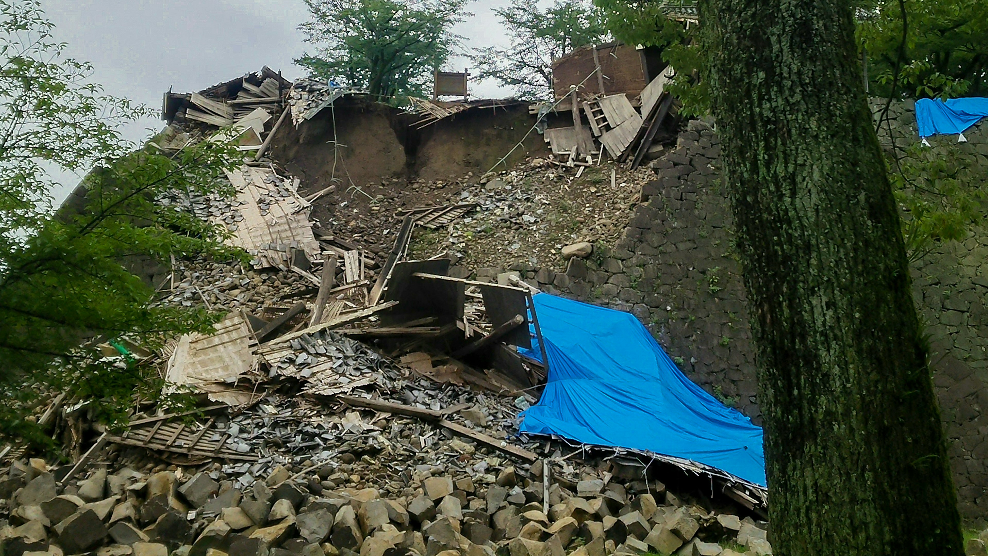 Murallas colapsadas con lonas azules visibles en el paisaje