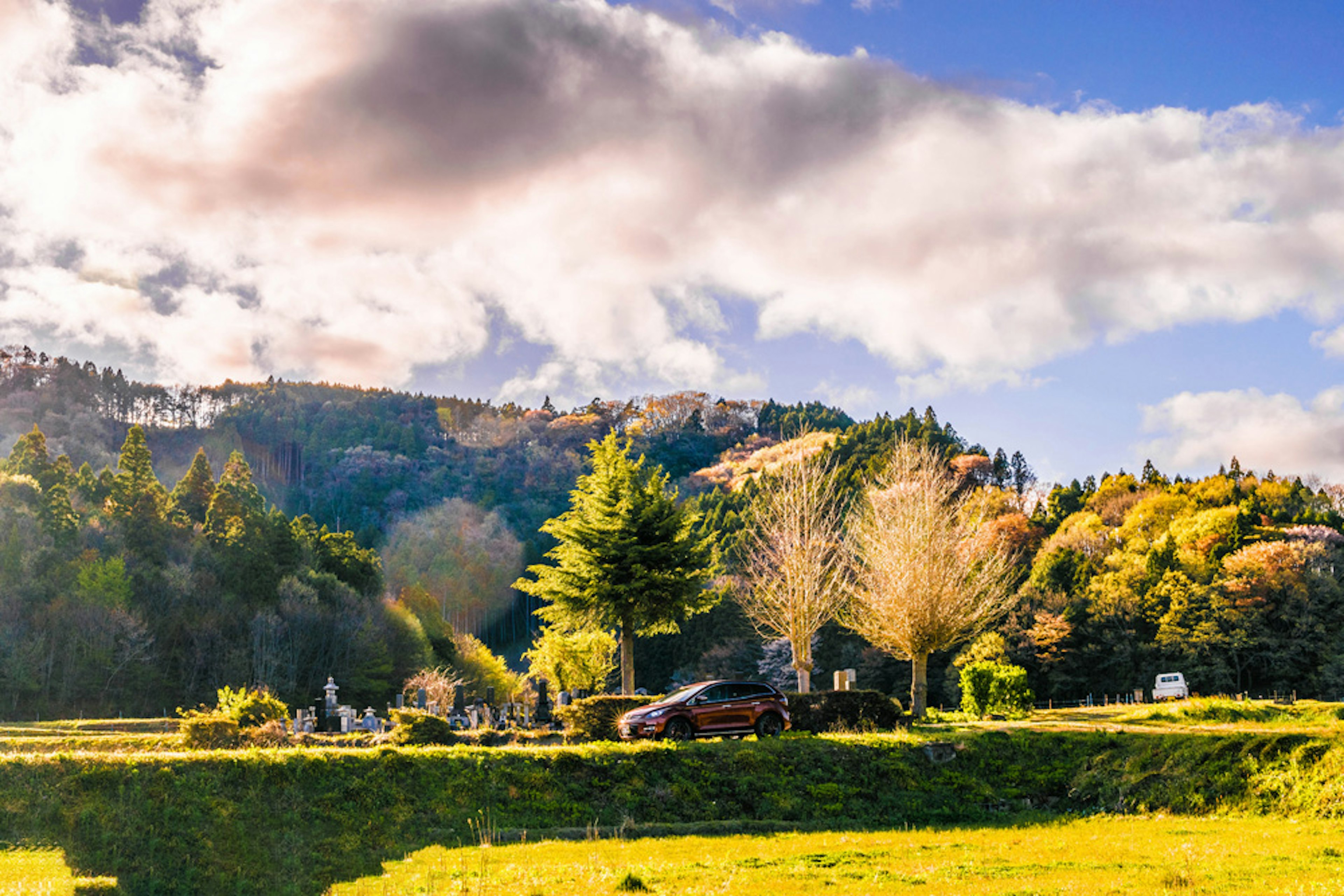 Vista escénica de montañas con vegetación exuberante y nubes en un cielo azul