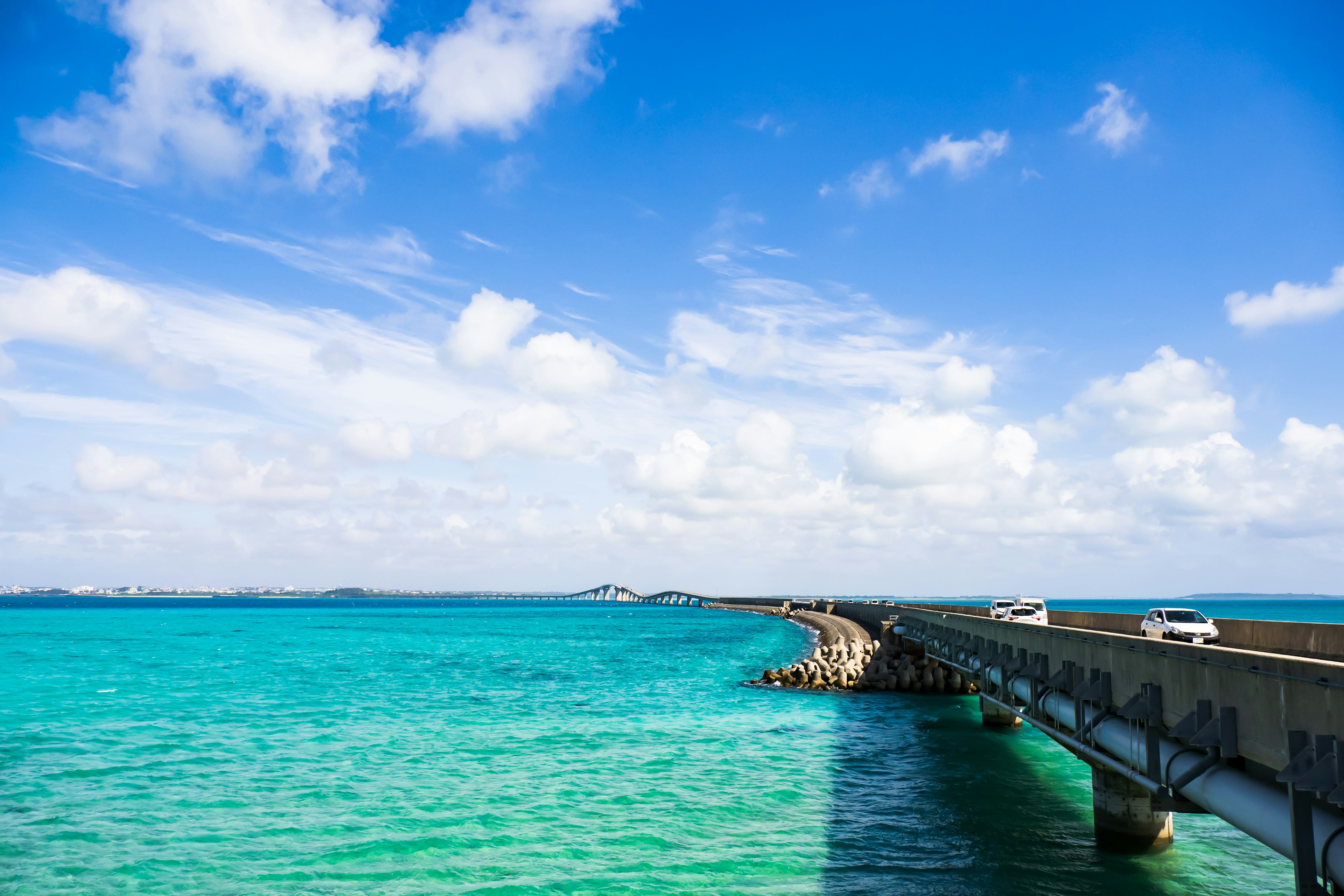 Eine malerische Aussicht auf eine Brücke, die über türkisfarbenes Wasser unter blauem Himmel verläuft