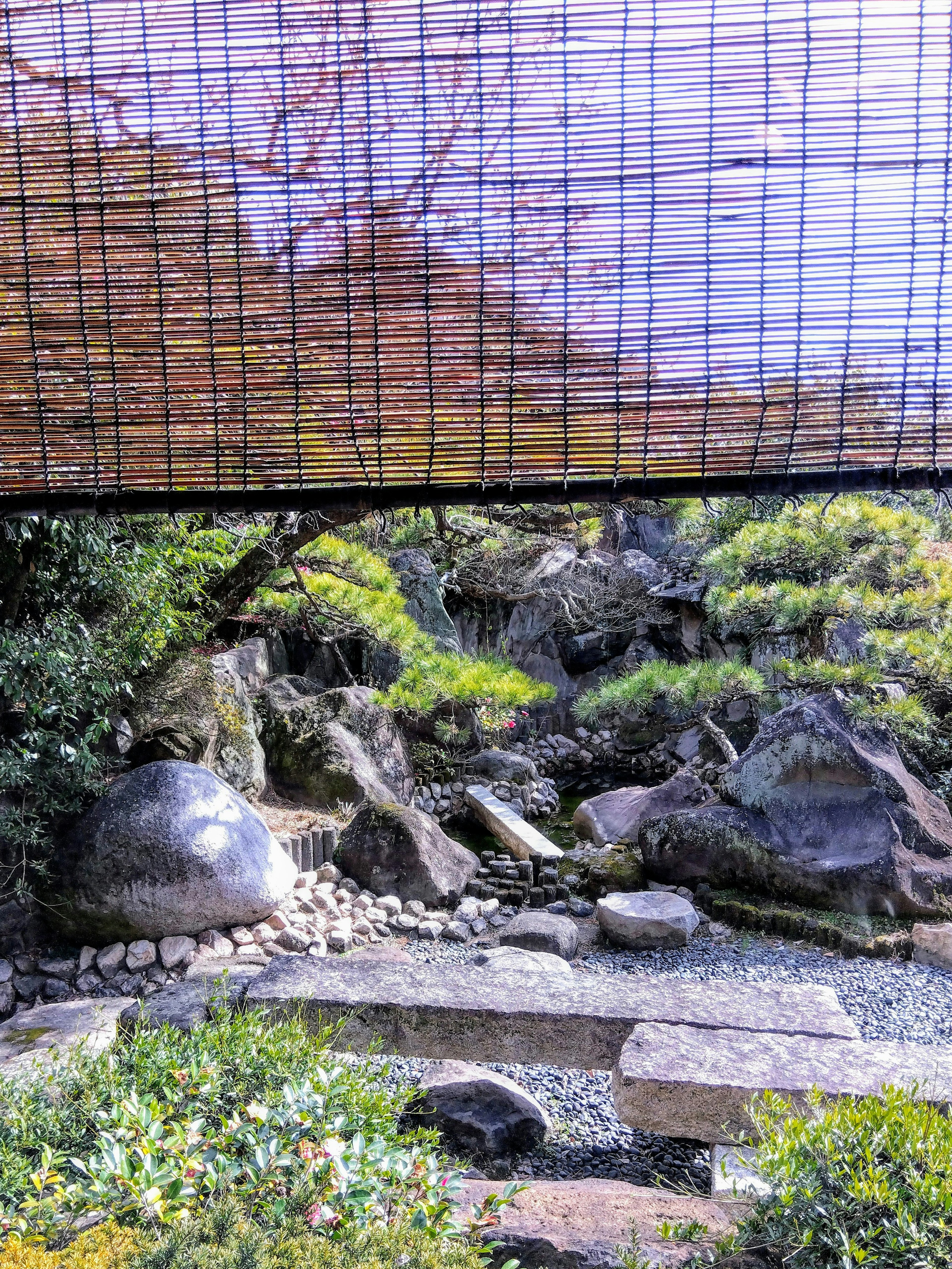 Bagian indah dari taman Jepang dengan batu alami dan vegetasi yang harmonis