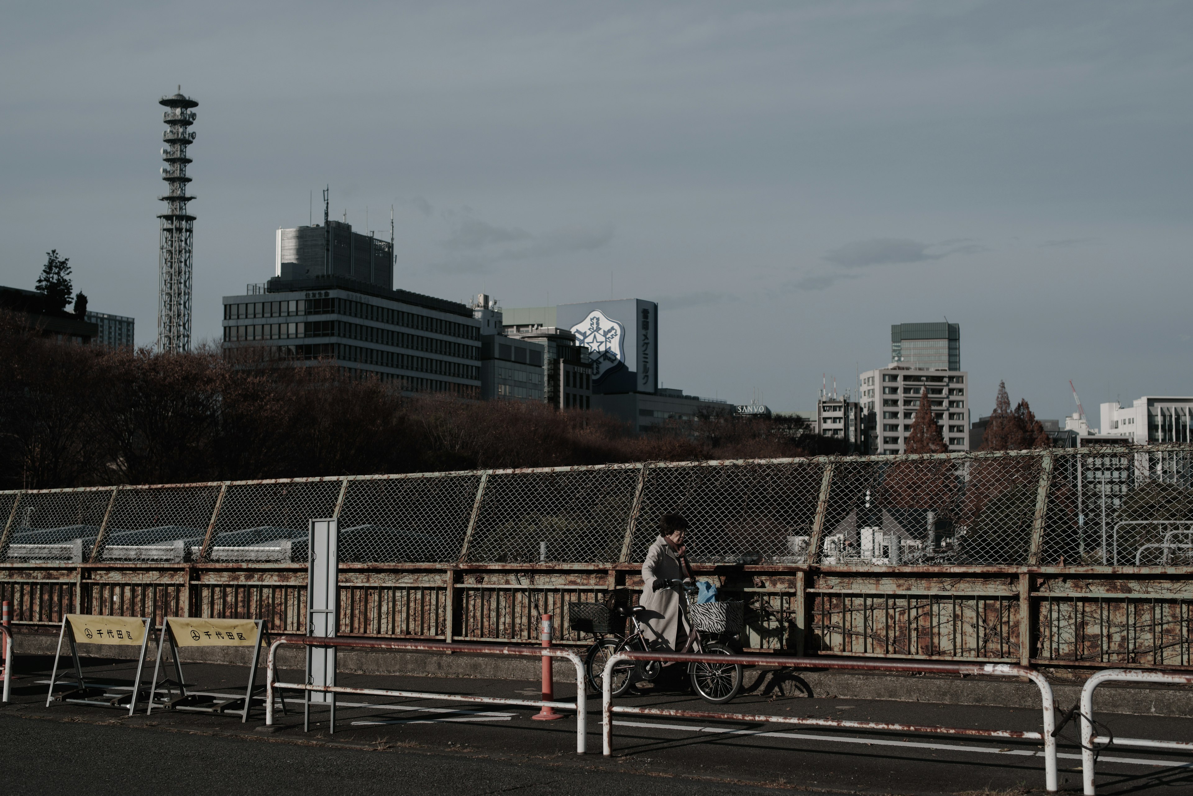 都市の風景で自転車に乗る人物が写っている薄暗い背景の画像