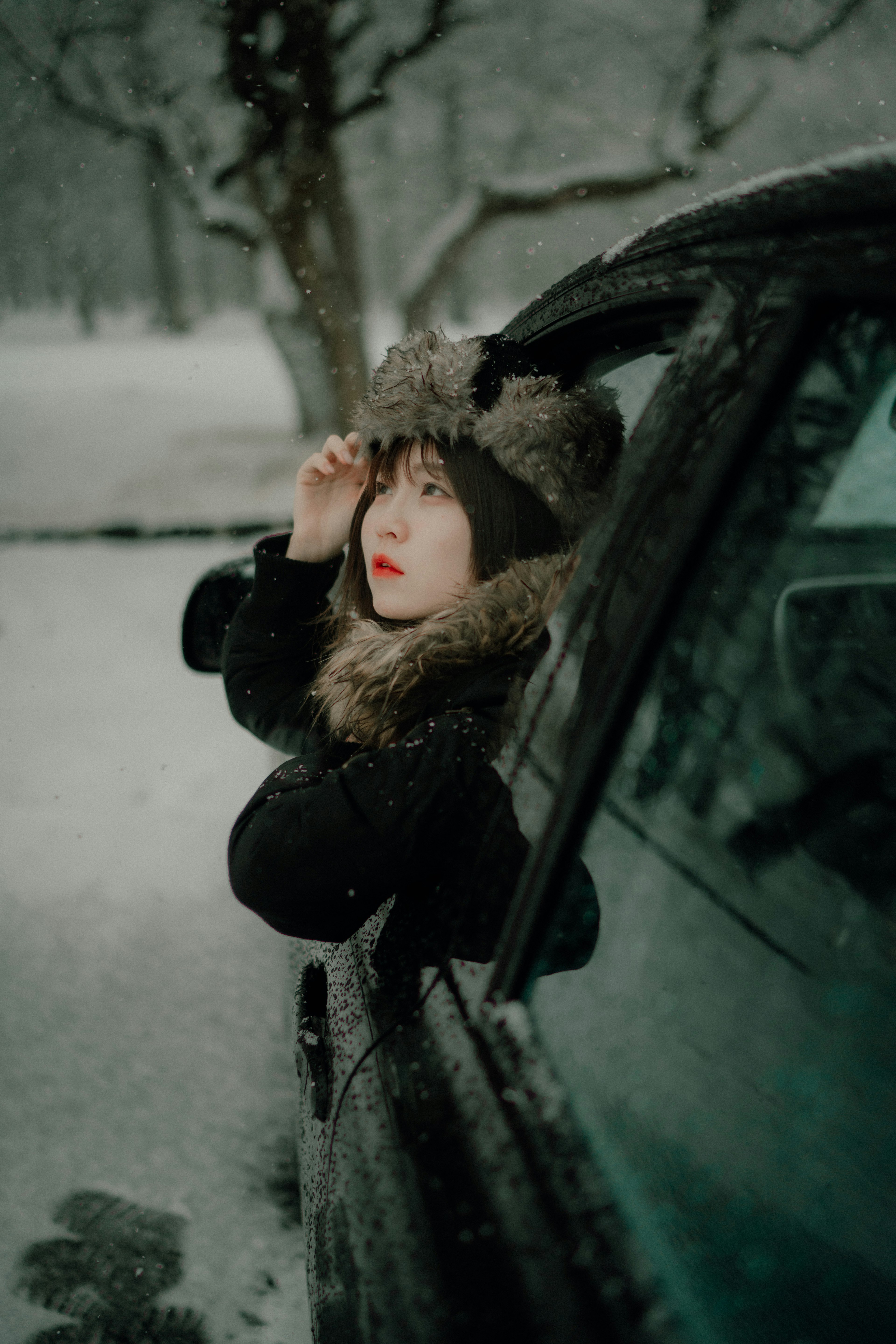 雪の中にいる女性が車の窓から顔を出しているシーン