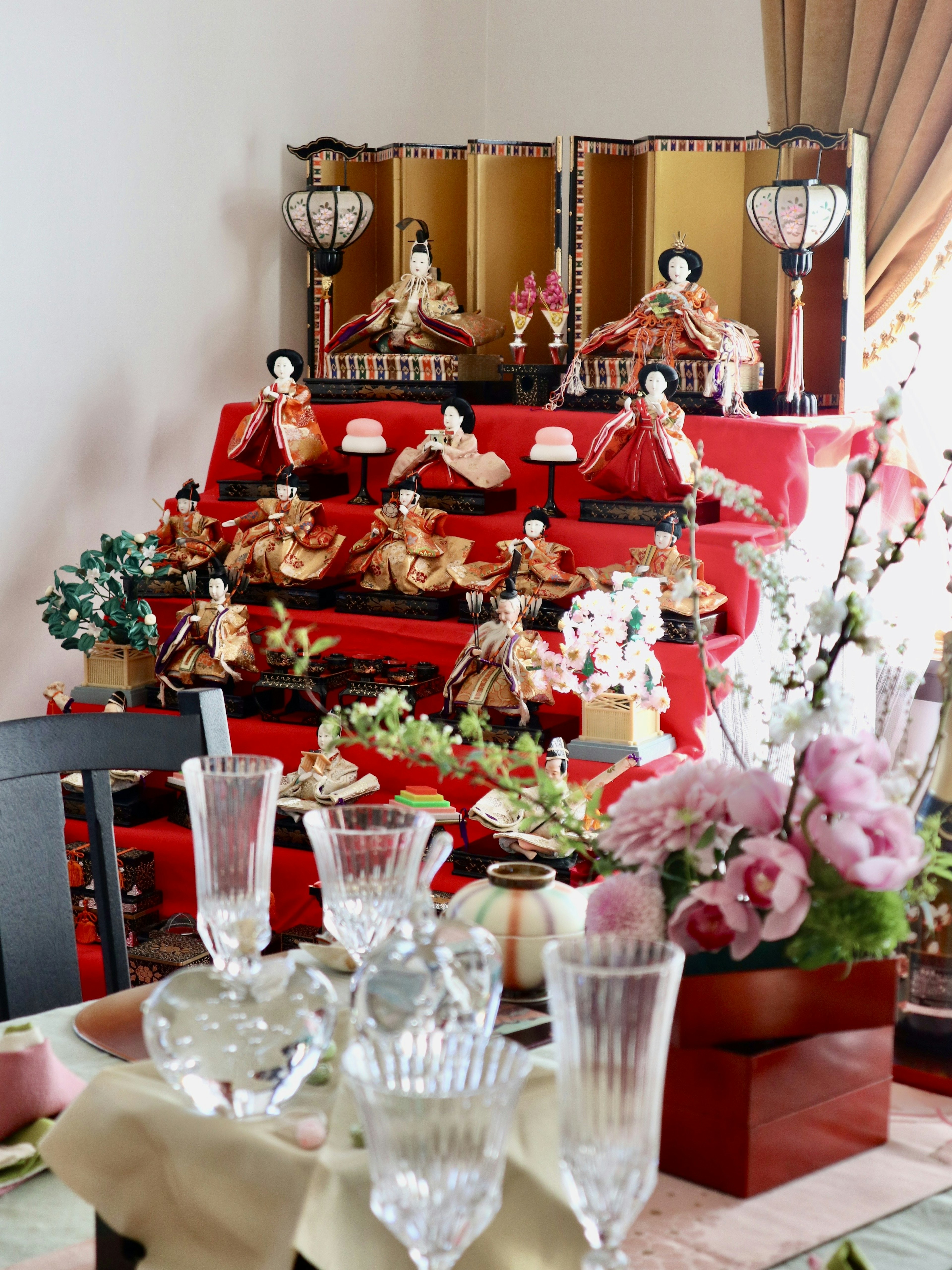 Exhibición de muñecas Hina para el festival Hinamatsuri con flores en la mesa