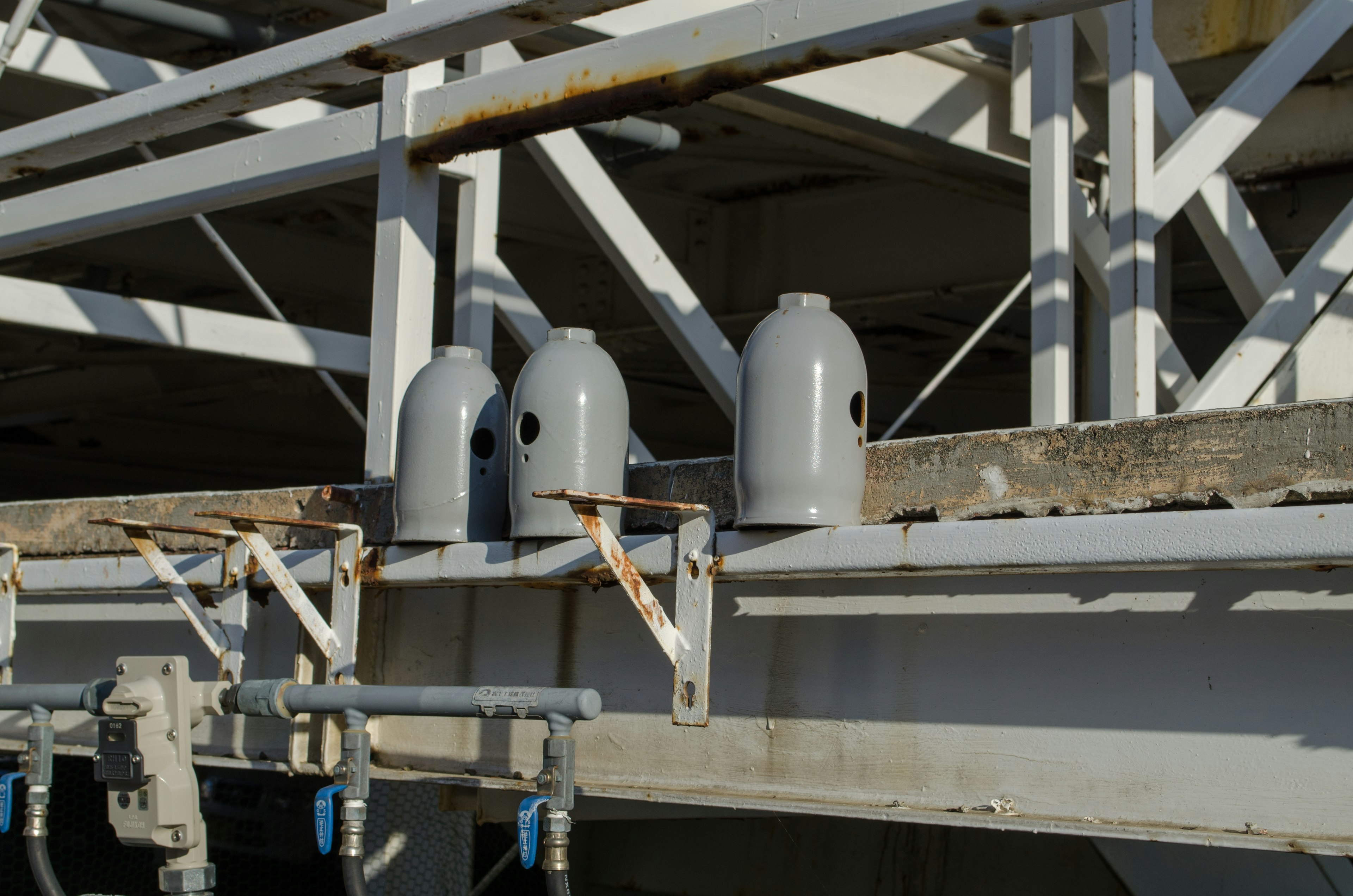 Gray industrial bottles placed on a metal structure