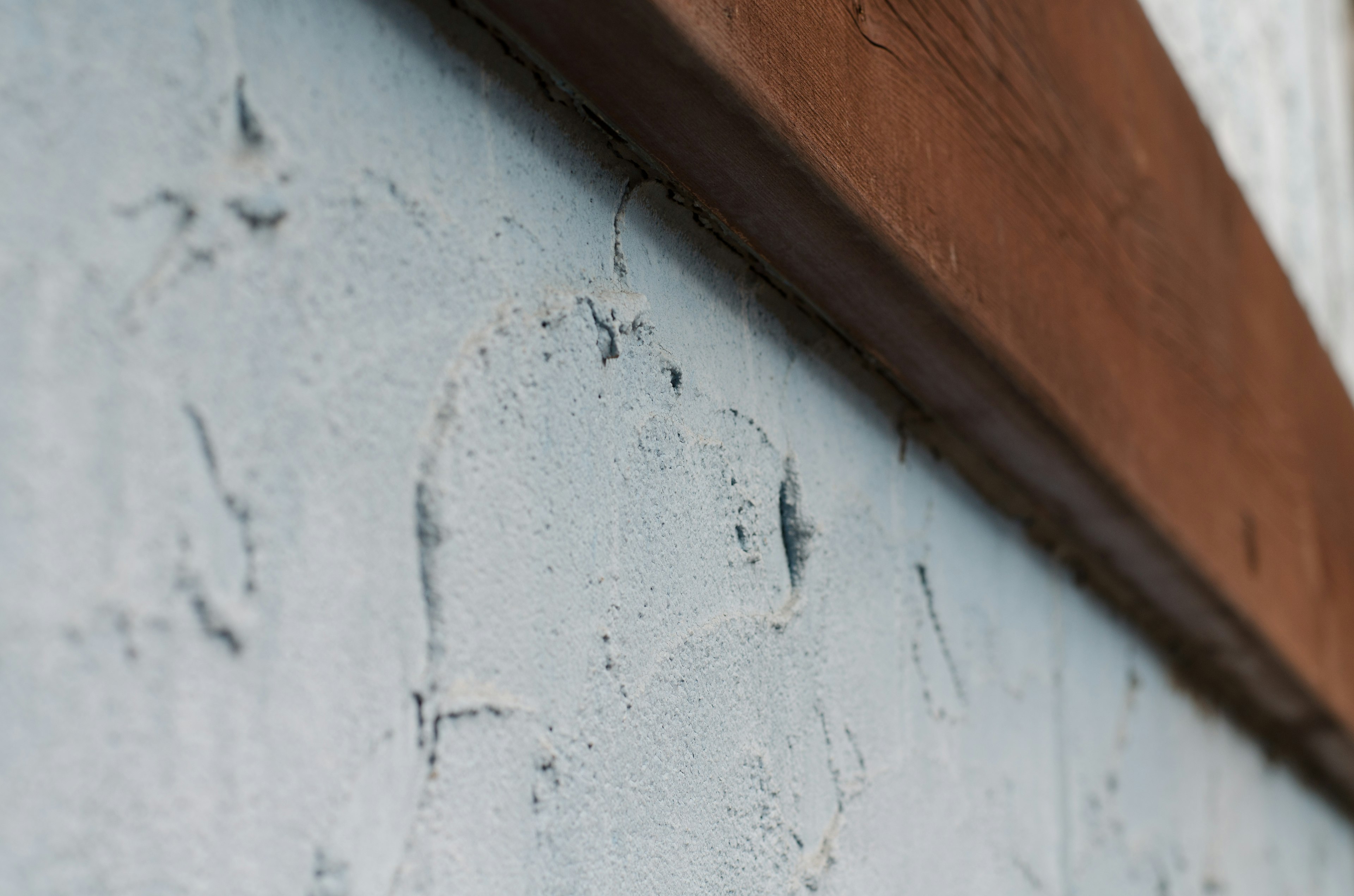 Close-up of a textured blue wall with a wooden beam