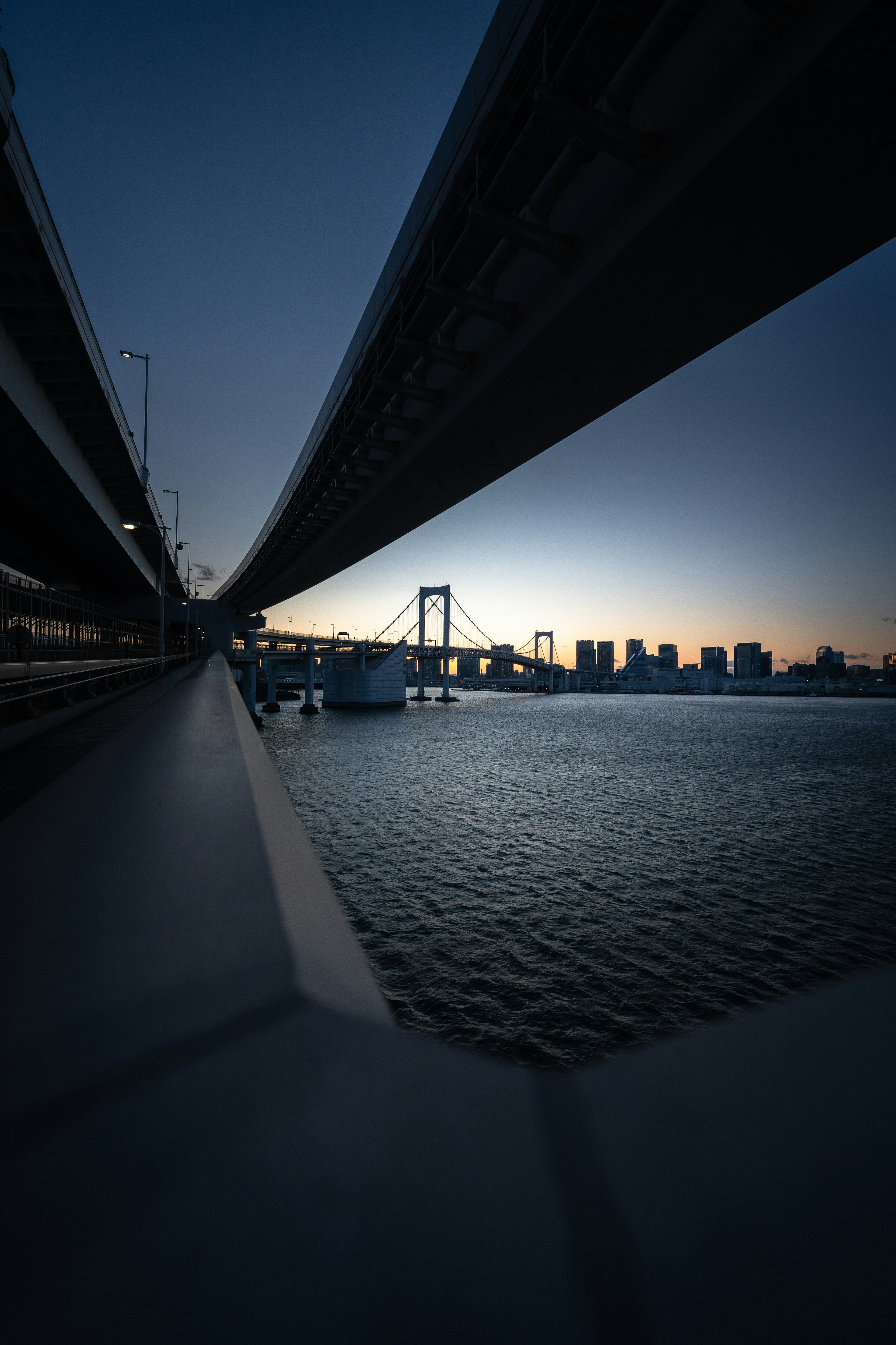 Rainbow Bridge über der Tokyo Bay bei Sonnenaufgang mit Stadtsilhouette