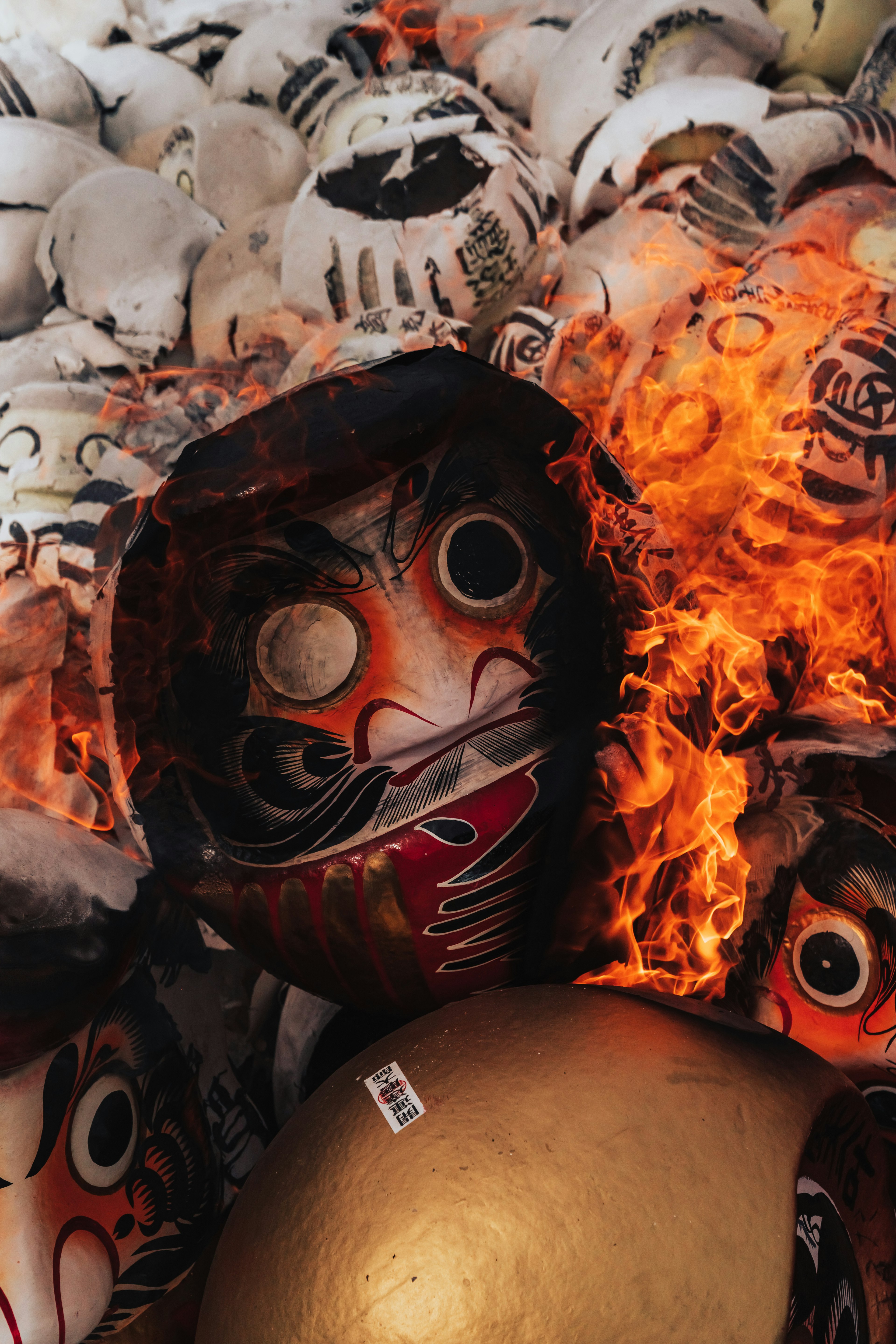 Image featuring traditional masks surrounded by flames and a golden ball