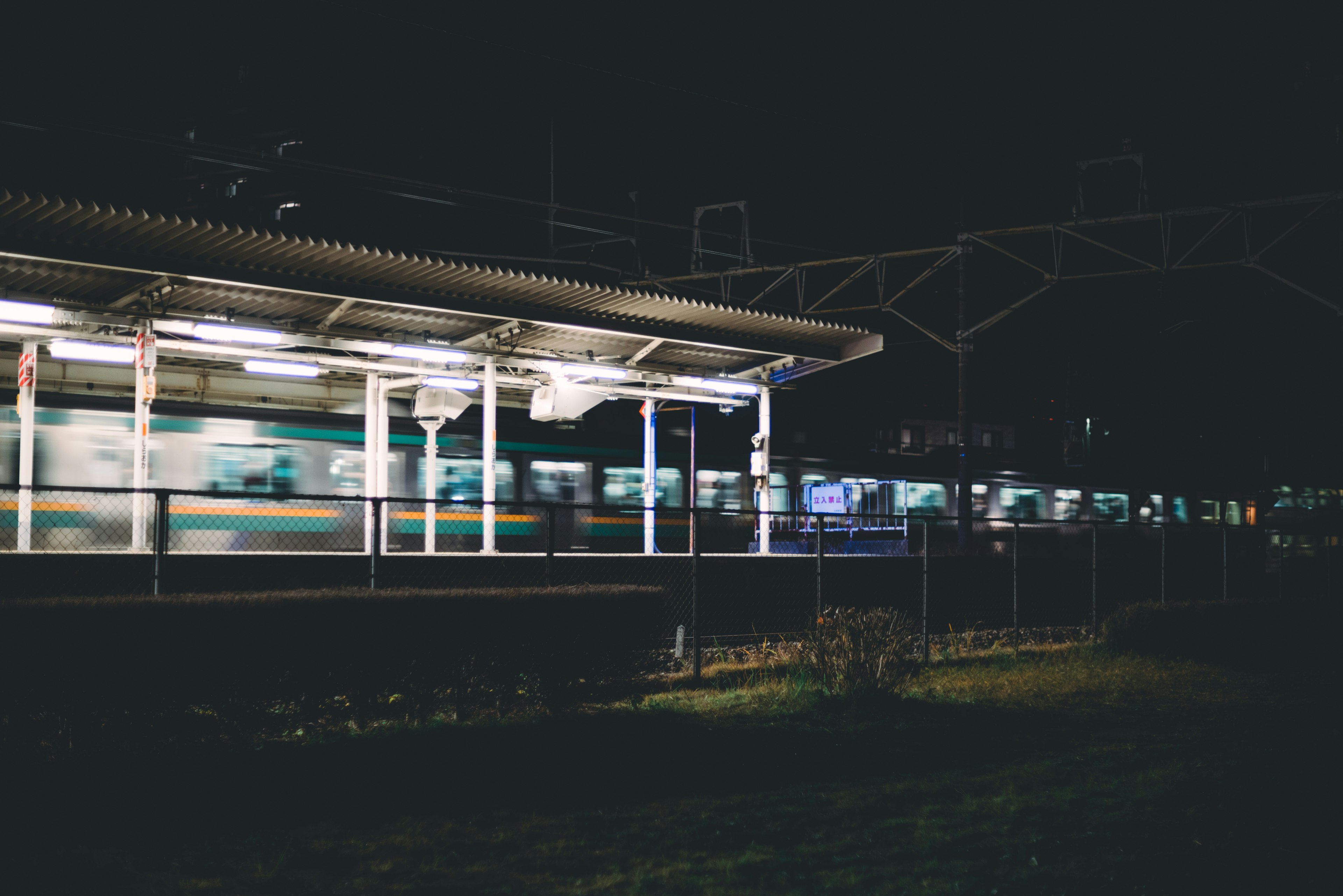 Train at night station with motion blur of passing train