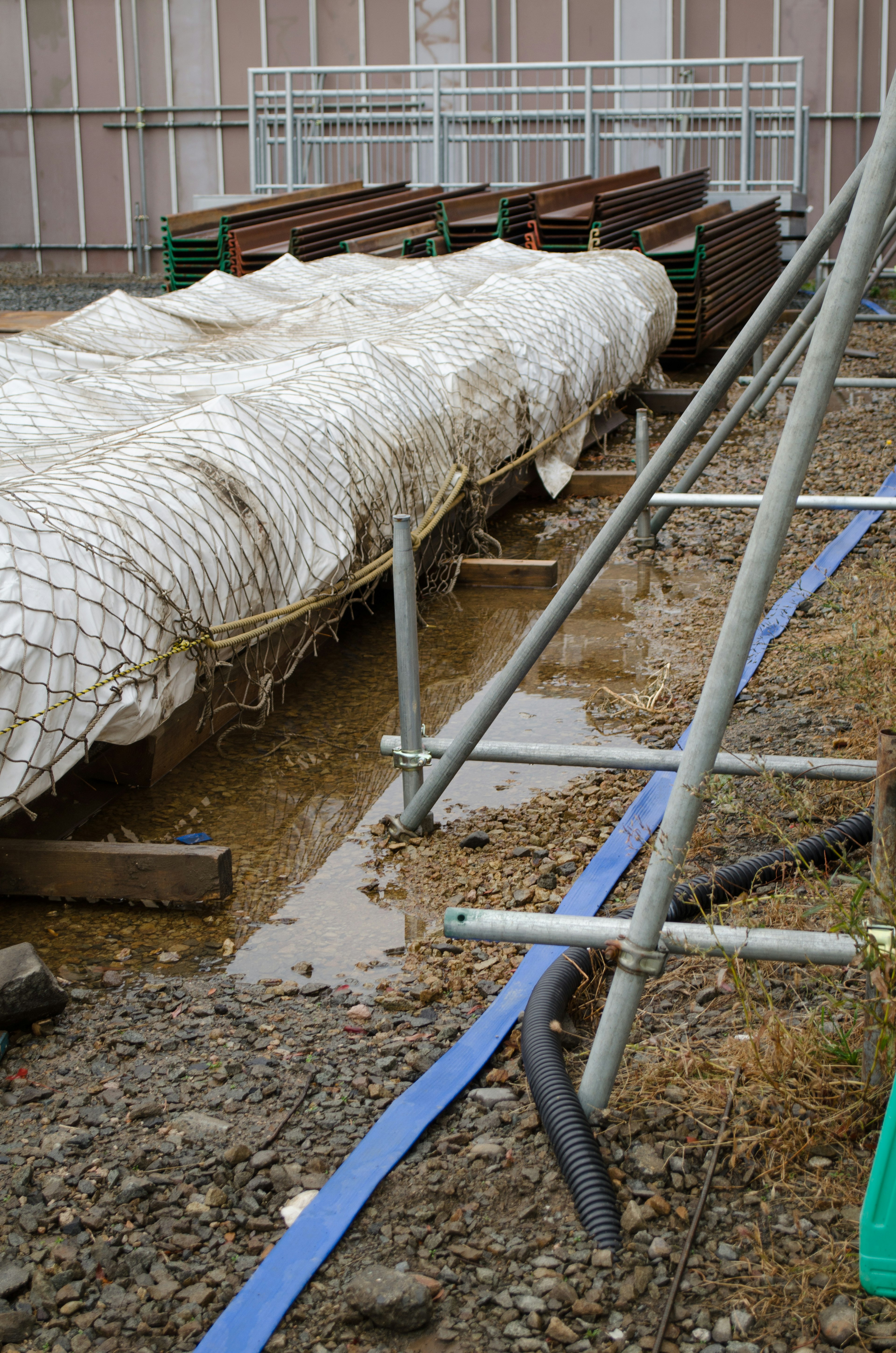 Sitio de construcción con una estructura cubierta y charcos de agua