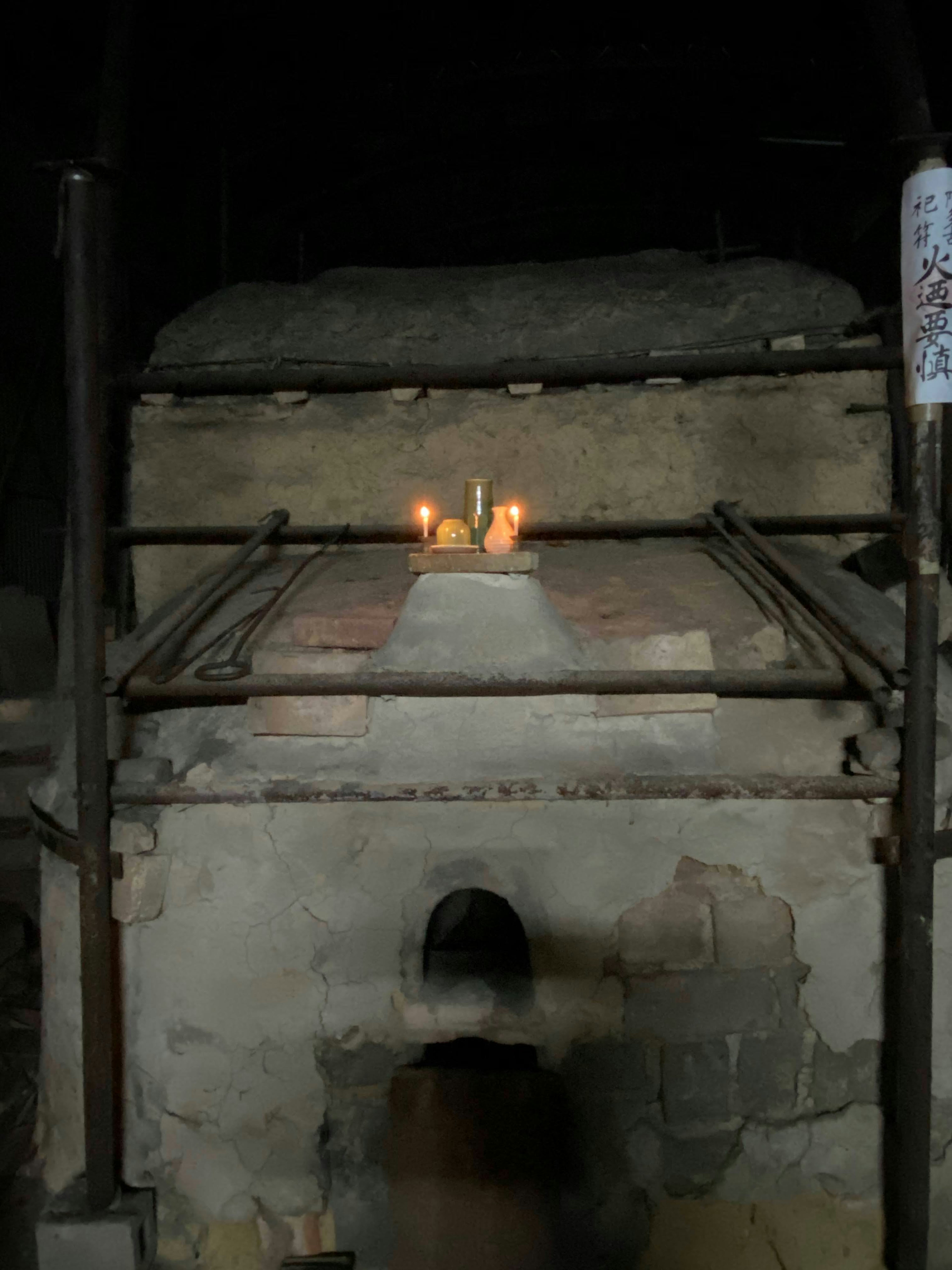 Candles lit on an old furnace with a stone top