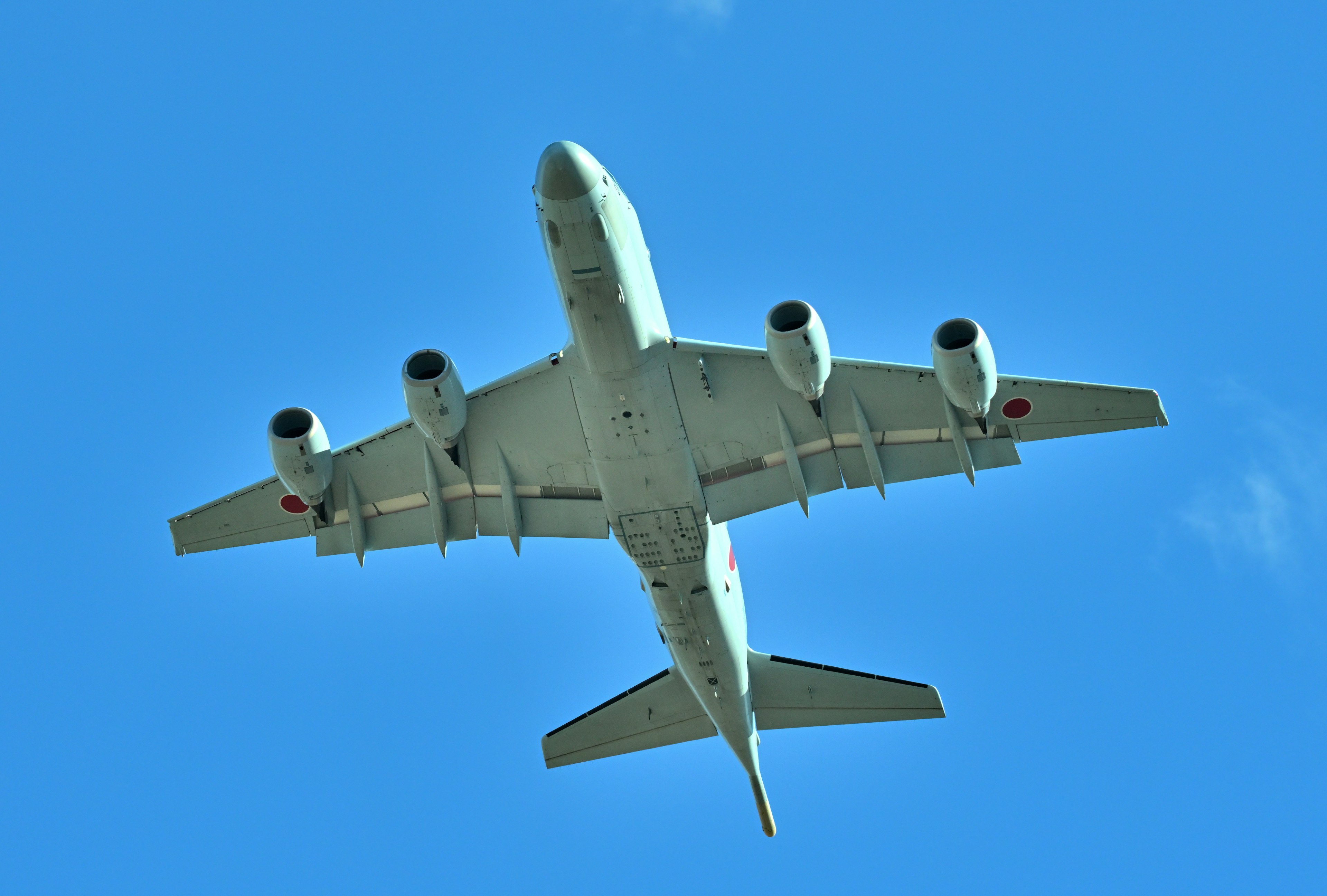 Vista di un aereo in volo contro un cielo blu dal basso