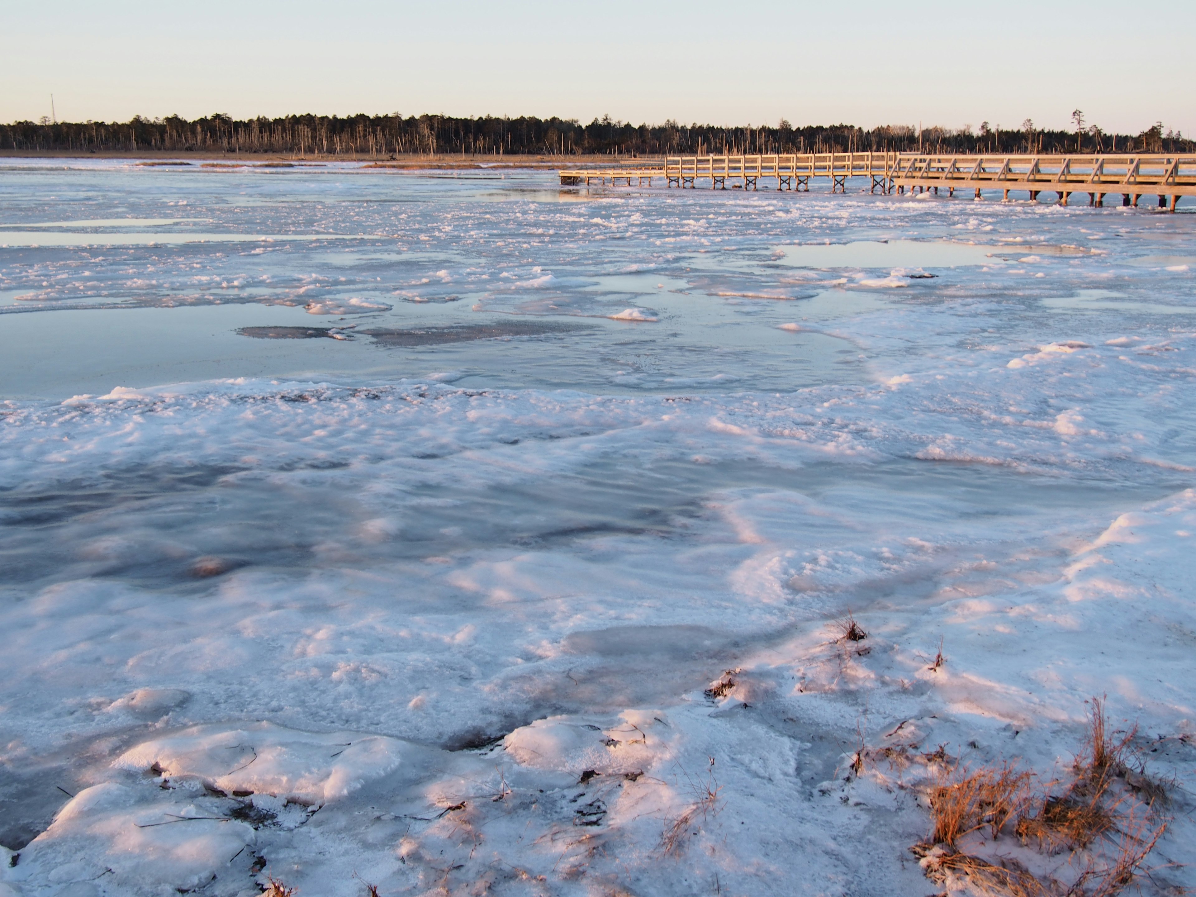 Superficie di lago ghiacciato con neve all'alba Luce riflessa che crea un'atmosfera serena