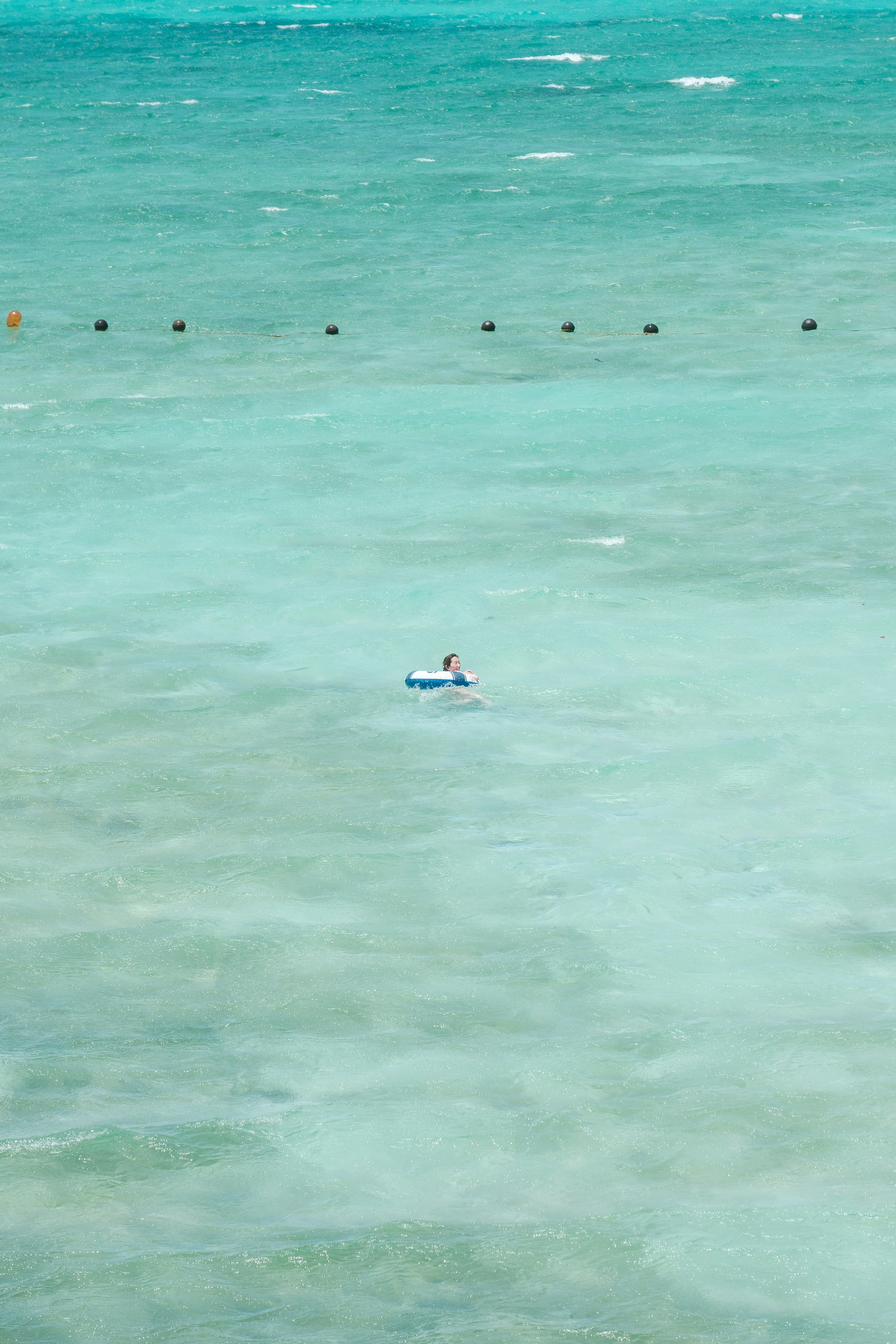 青い海の中に浮かぶ小さなボートと人