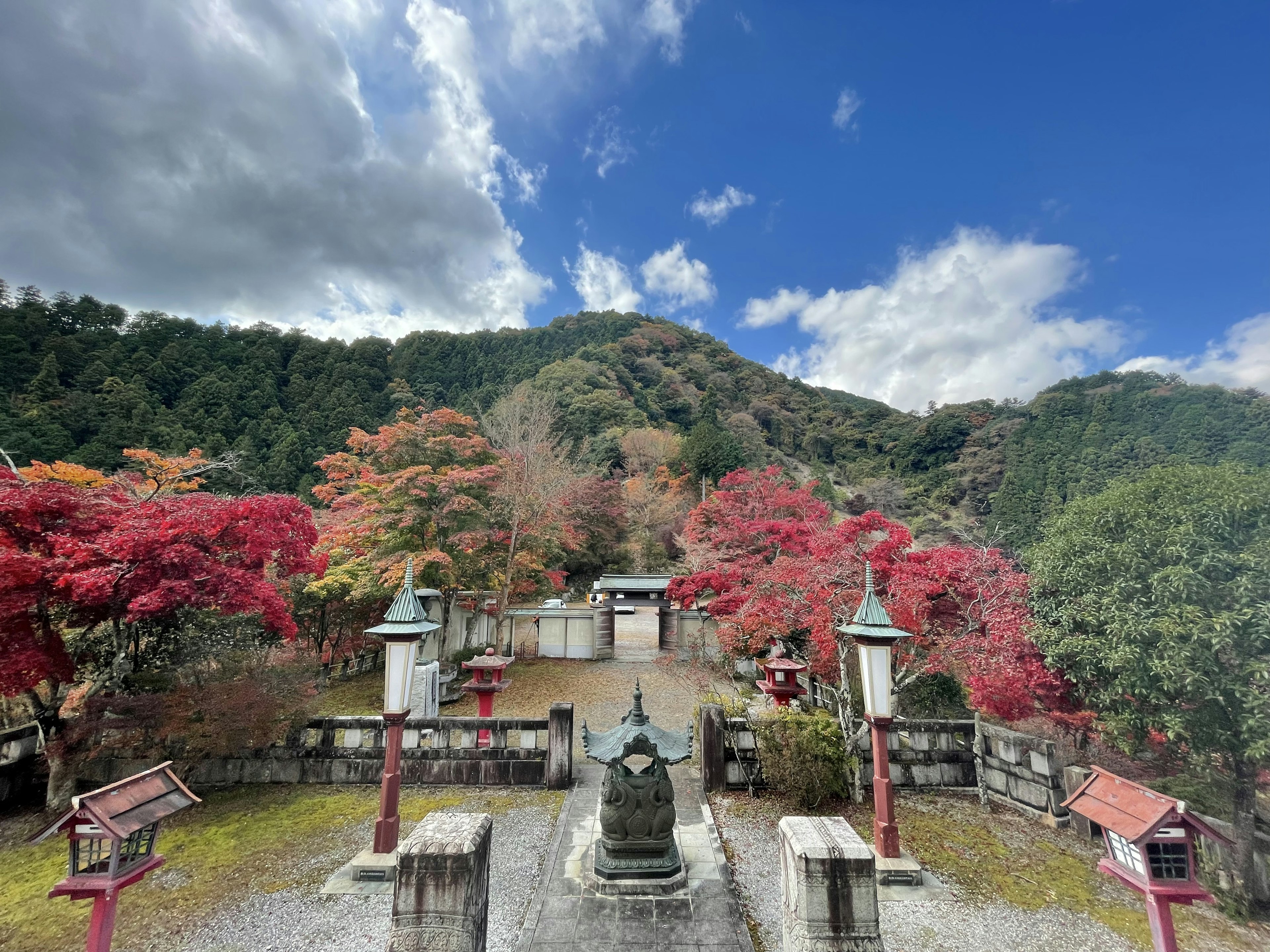 Vista panoramica di un tempio circondato da fogliame autunnale vibrante con cielo blu e nuvole