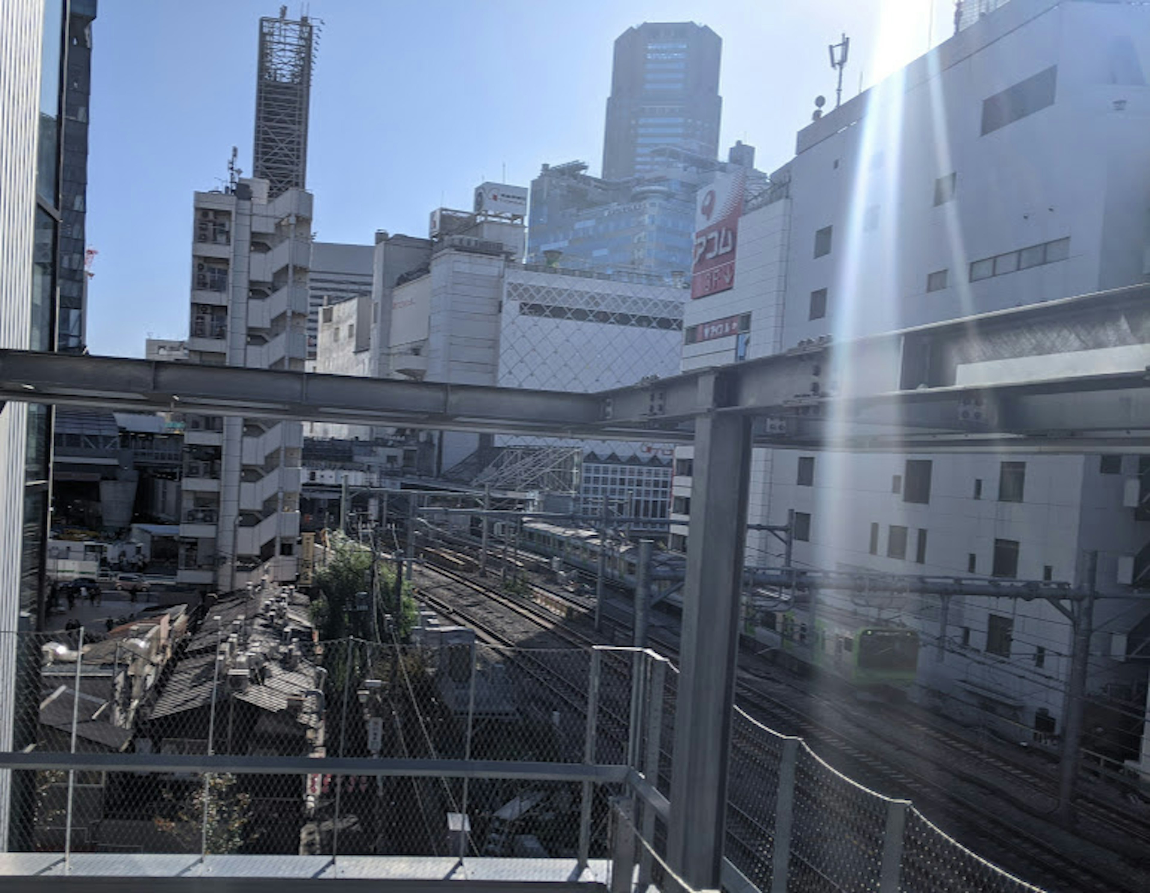 Paysage urbain avec des immeubles de grande hauteur et des voies ferrées sous un ciel bleu lumineux