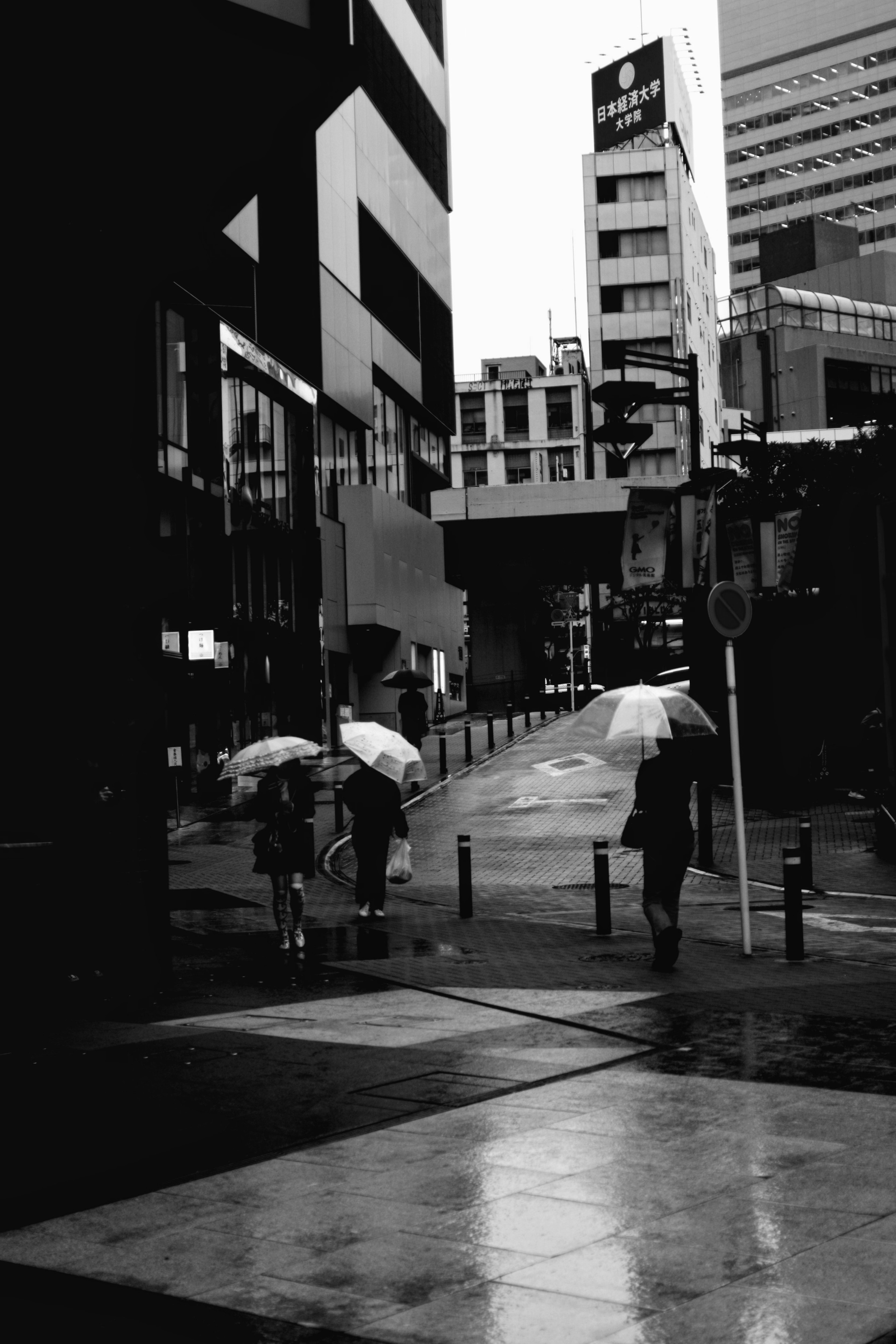 雨の中で傘を持って歩く人々と都市のビル