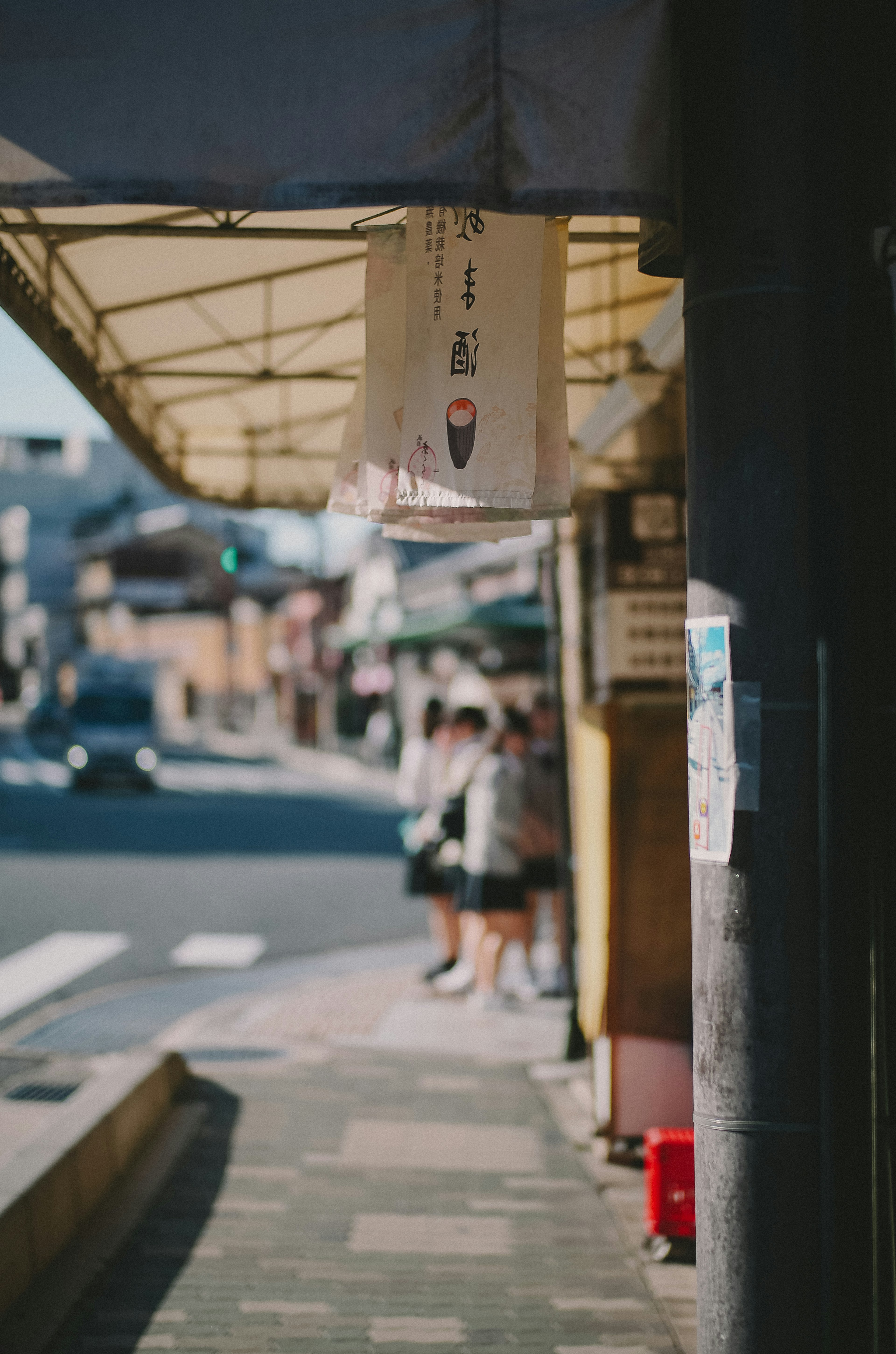 Street view featuring a shop sign and pedestrians in a commercial area