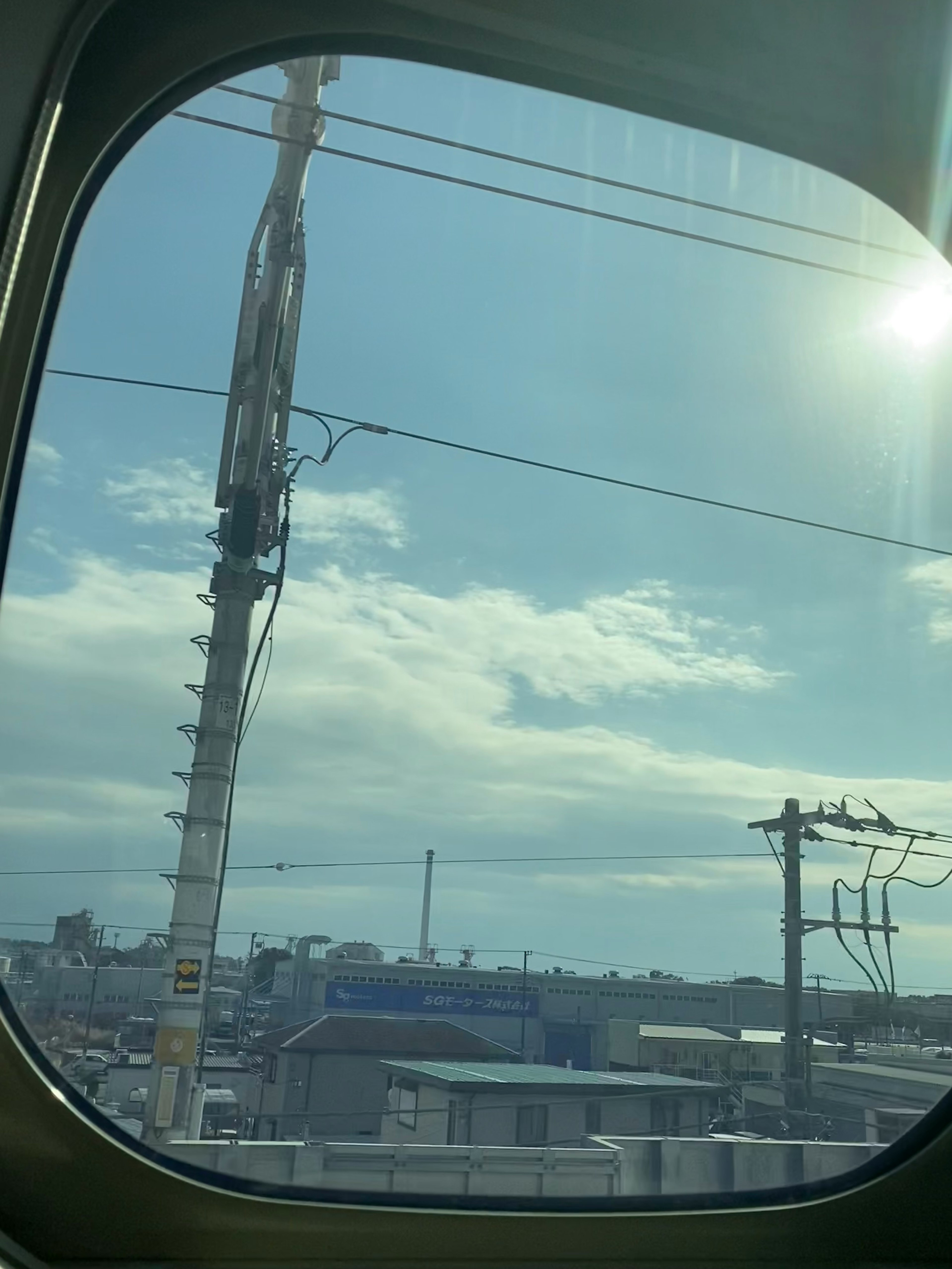 列車の窓からの風景 青空と白い雲 電柱と電線