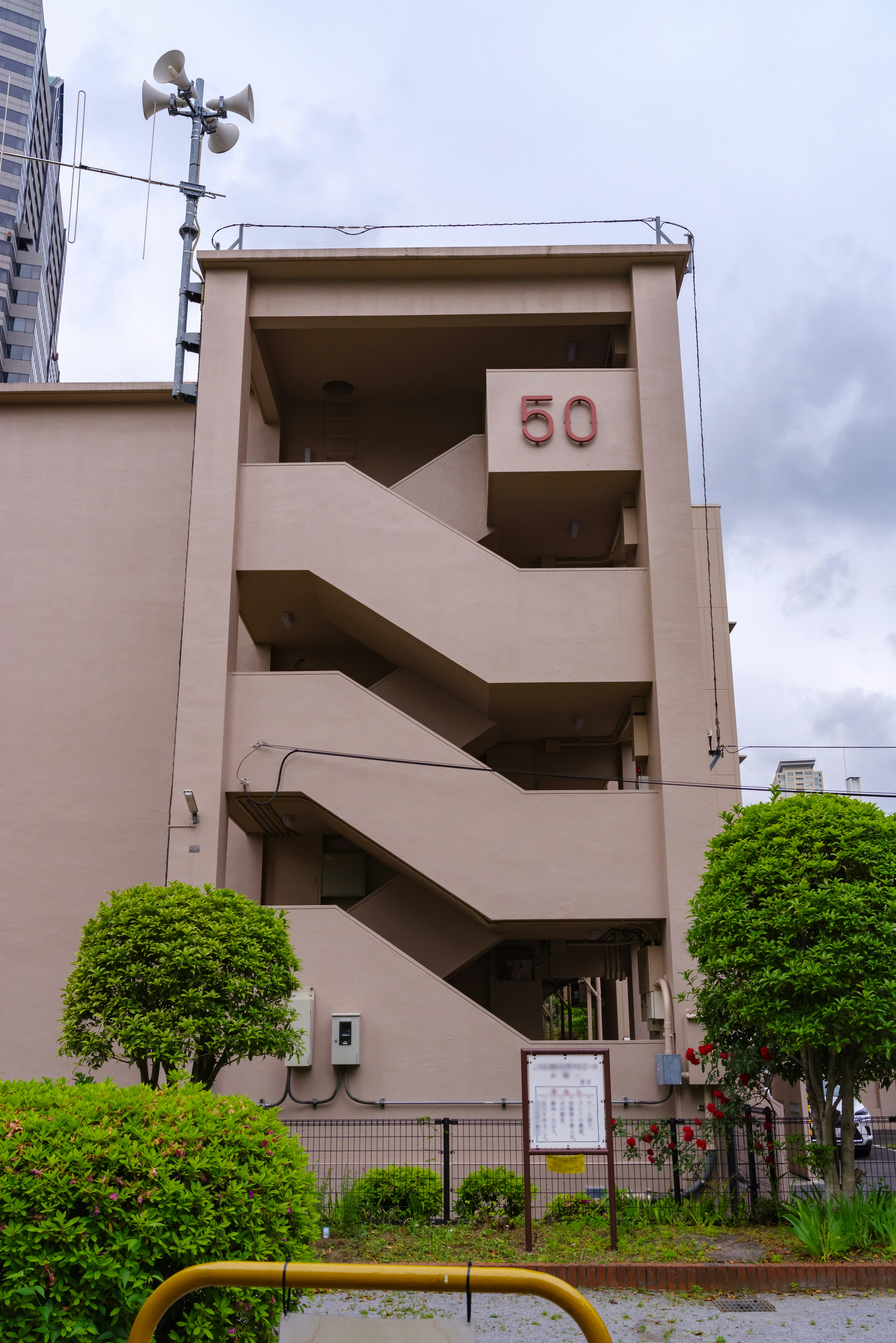 Exterior view of a brown building featuring a staircase and the number 50