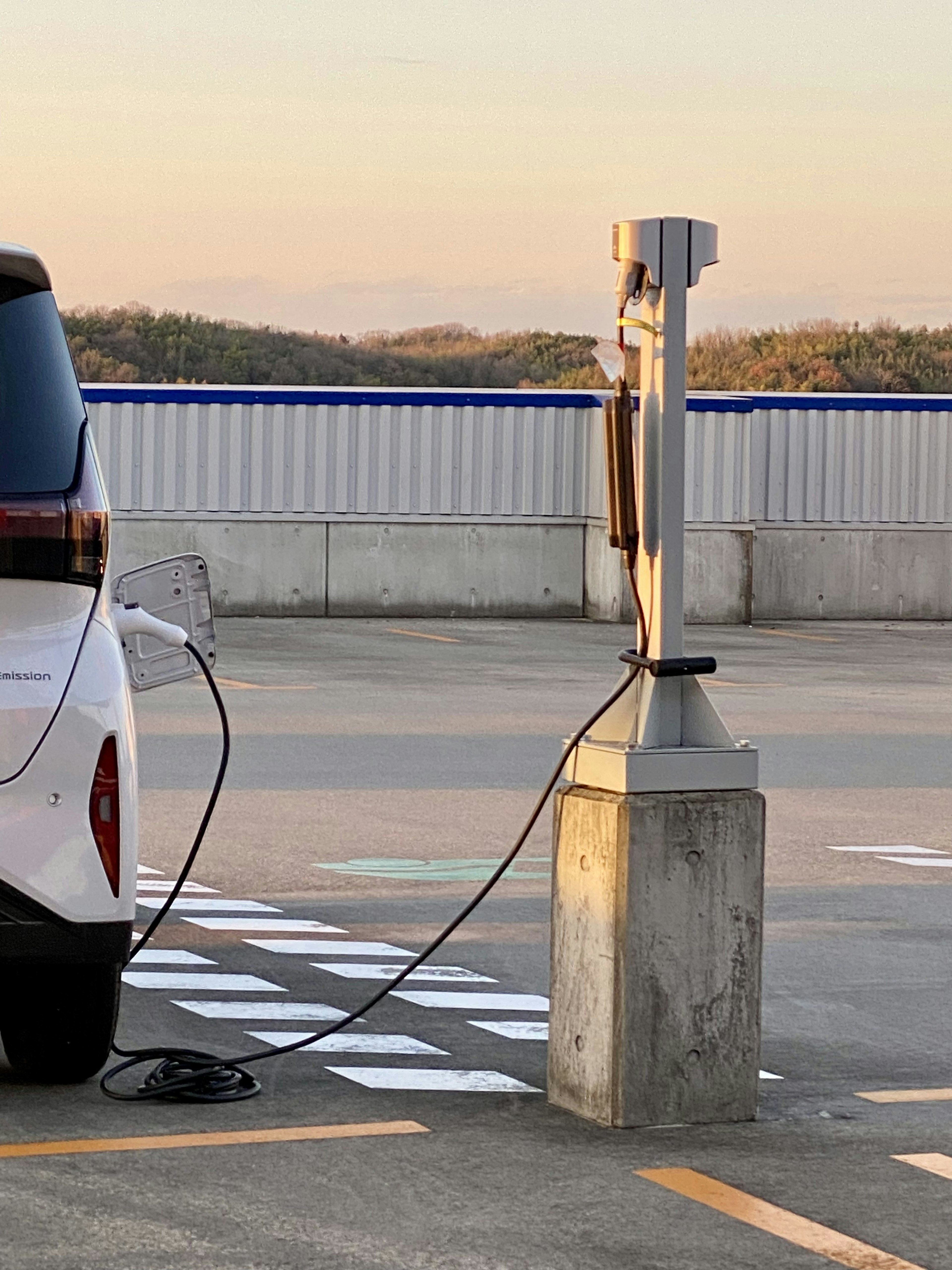 Elektrofahrzeug wird an einer Ladestation auf einem Parkplatz aufgeladen