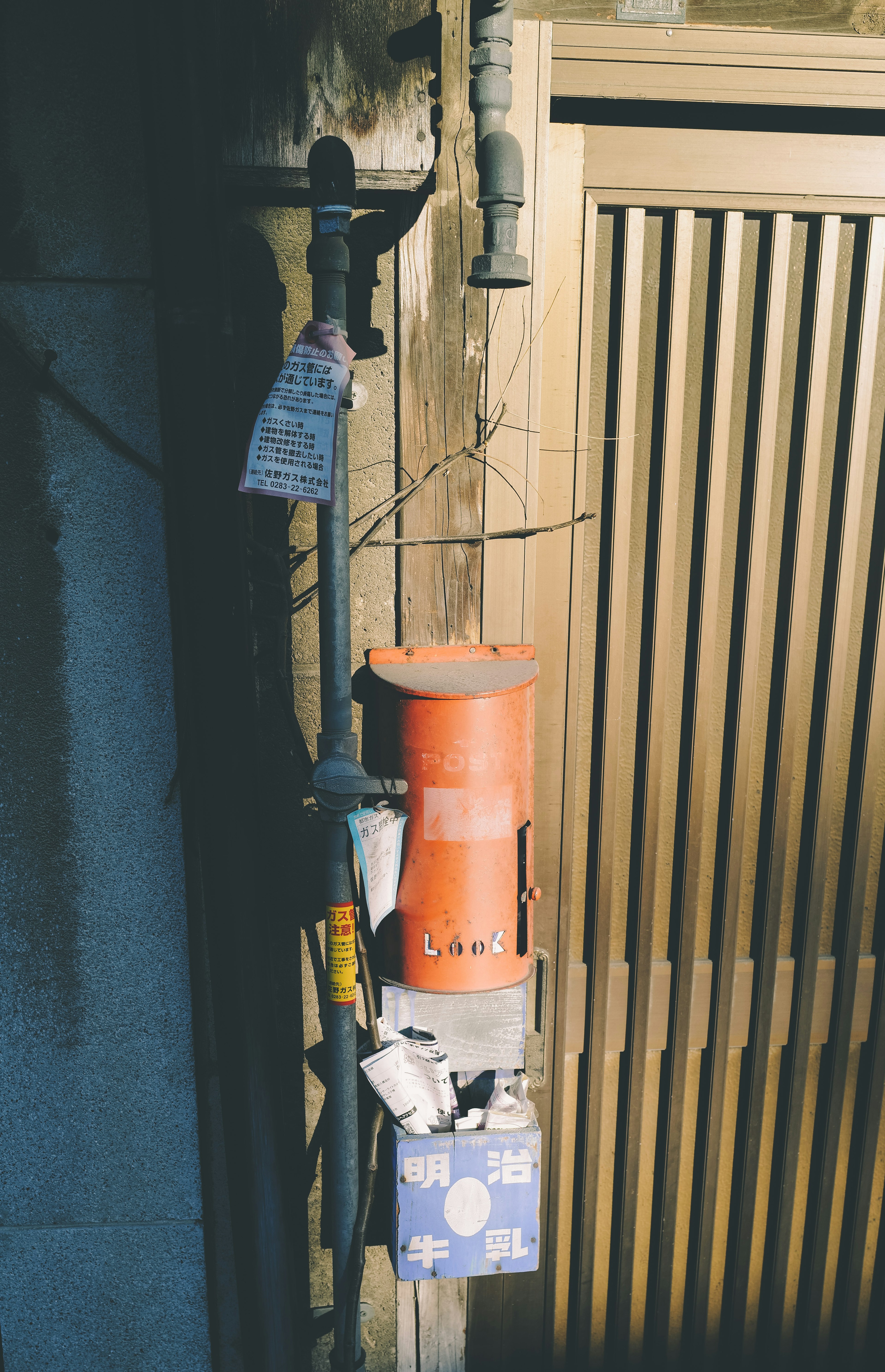 Una sección de pared con una caja naranja y un letrero azul