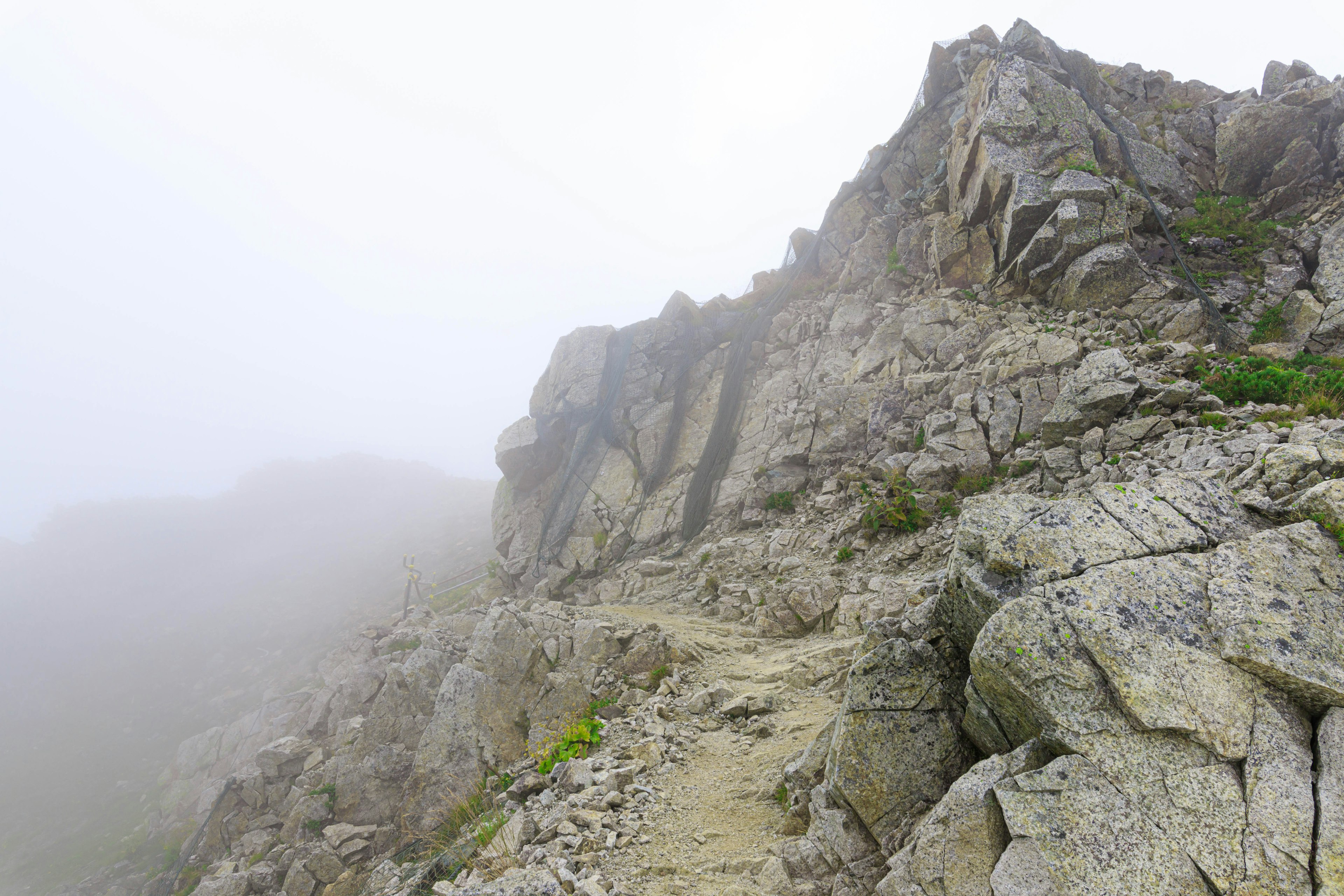 Paisaje montañoso rocoso envuelto en niebla