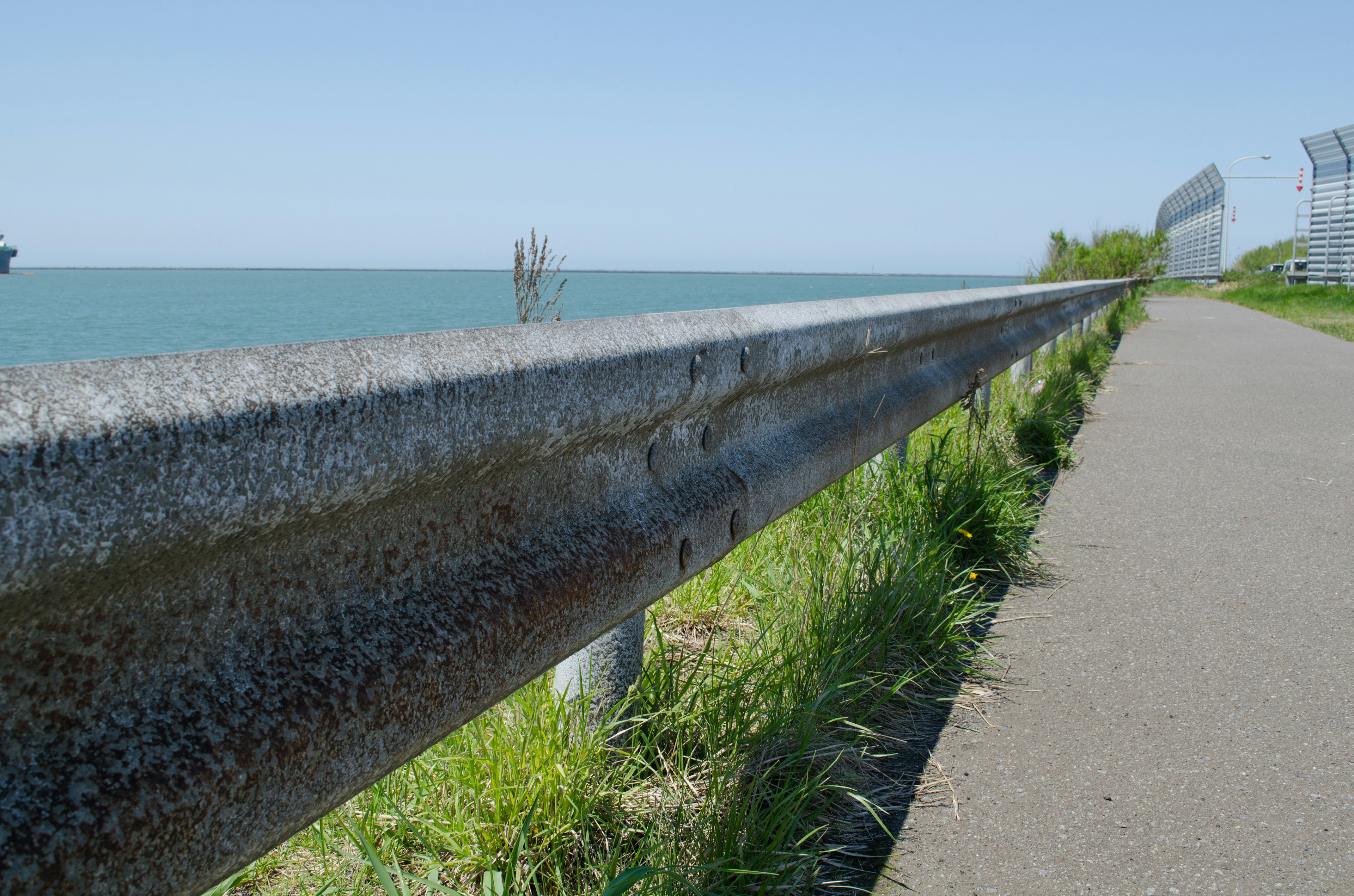 Metallgeländer in der Nähe eines gepflasterten Gehwegs am Meer