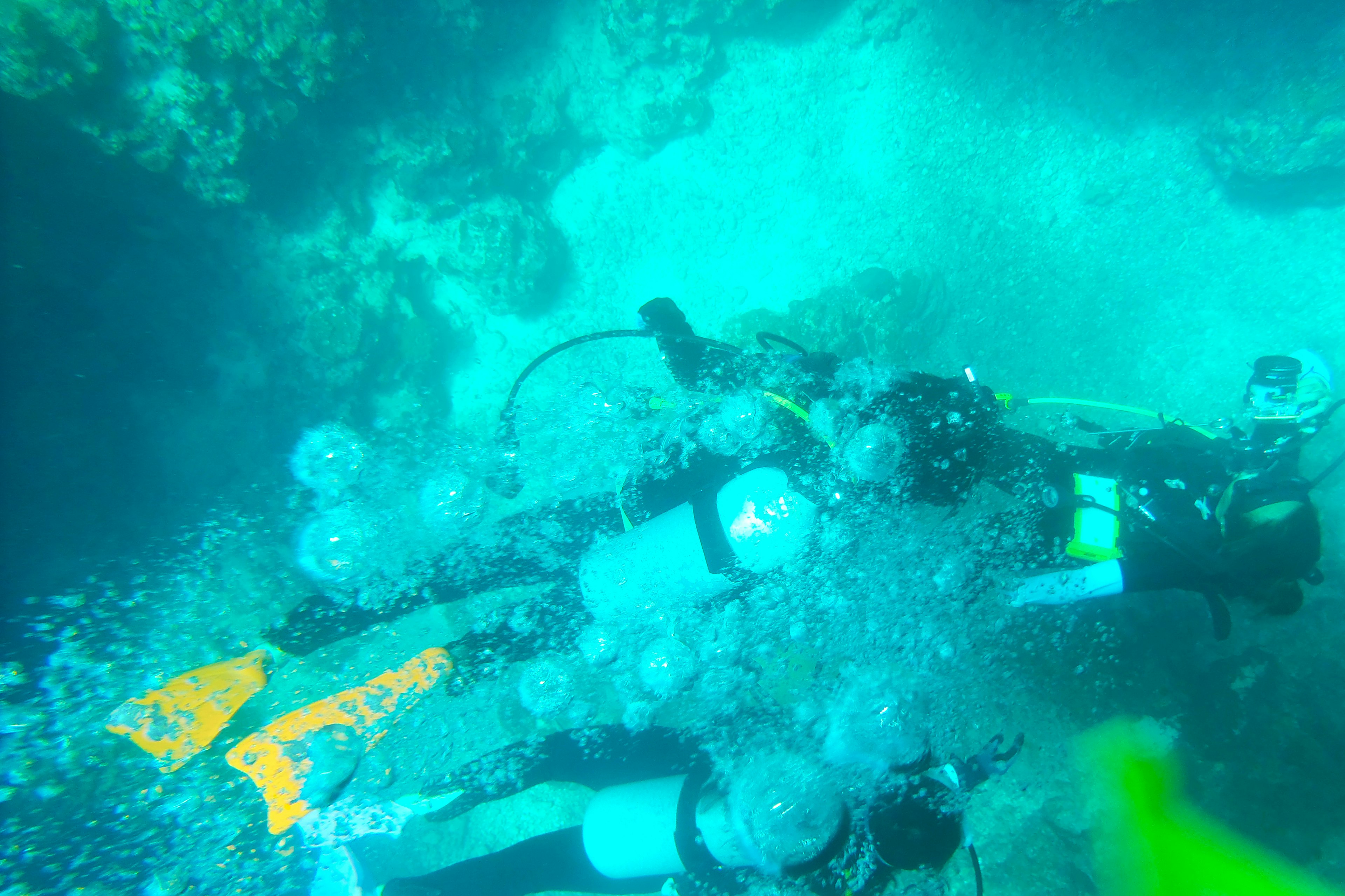 Divers underwater surrounded by bubbles in a blue ocean scene