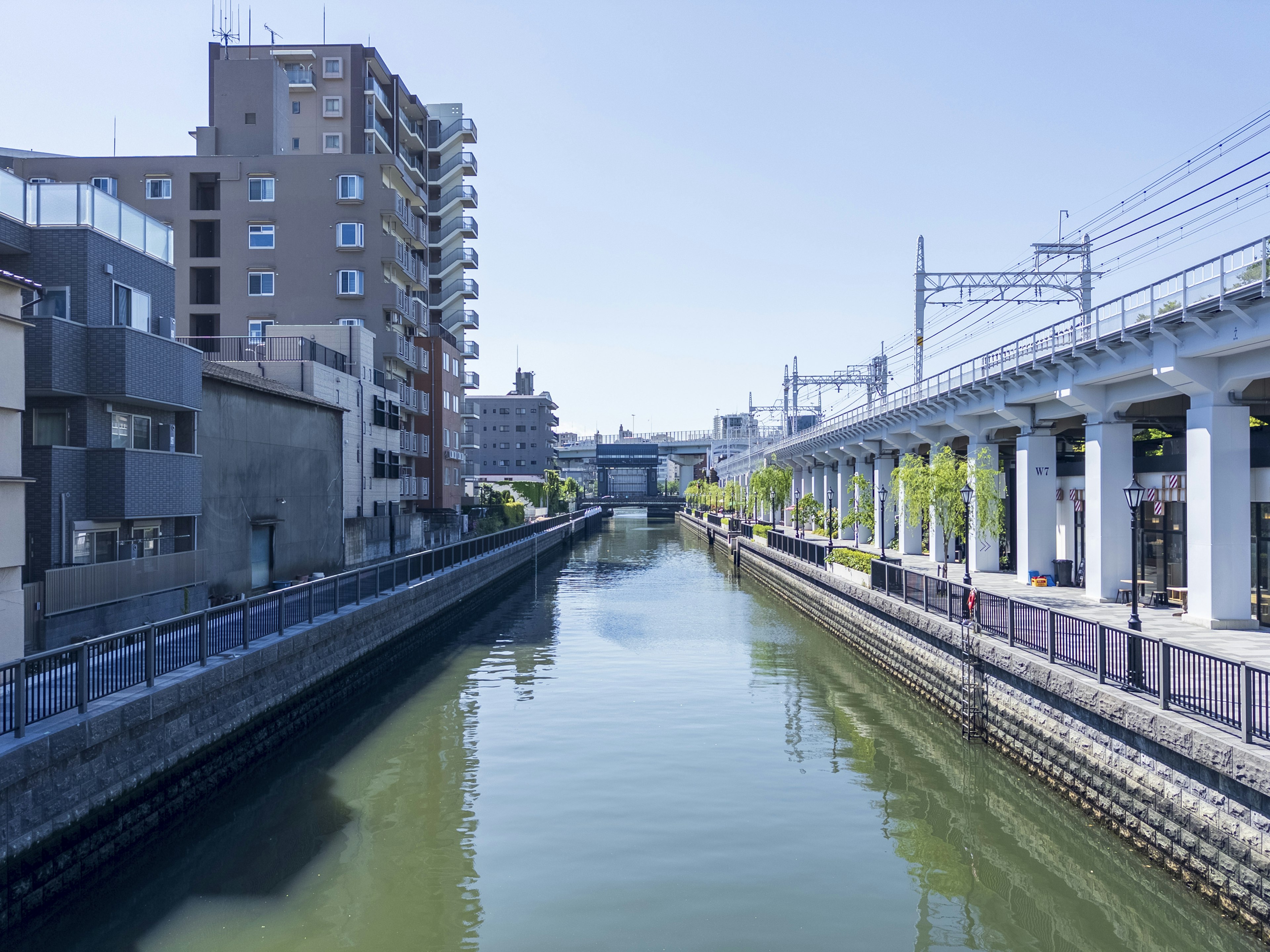 Urban landscape along a river with an elevated train track