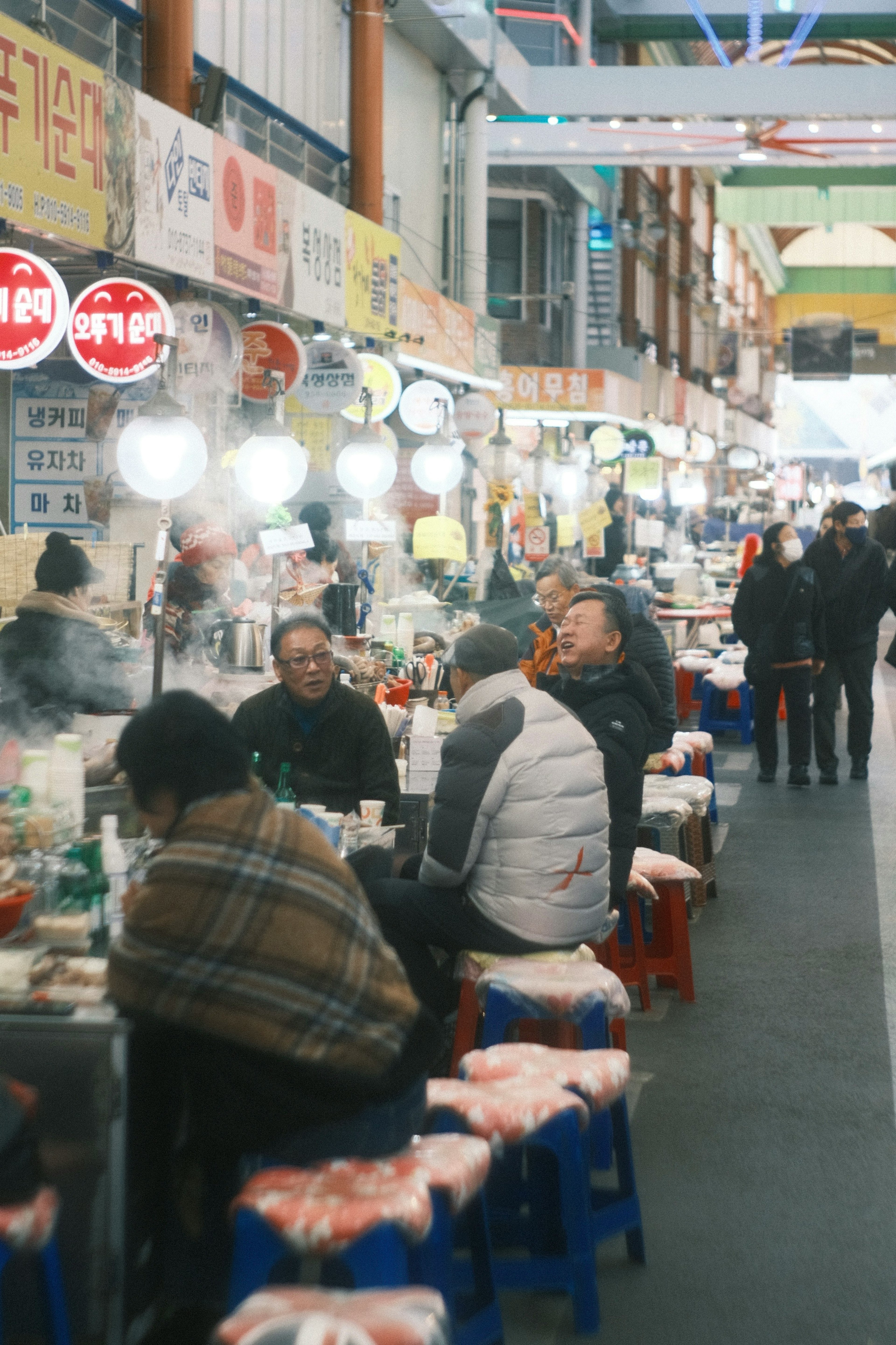 Bustling food street with people sitting and enjoying warm meals