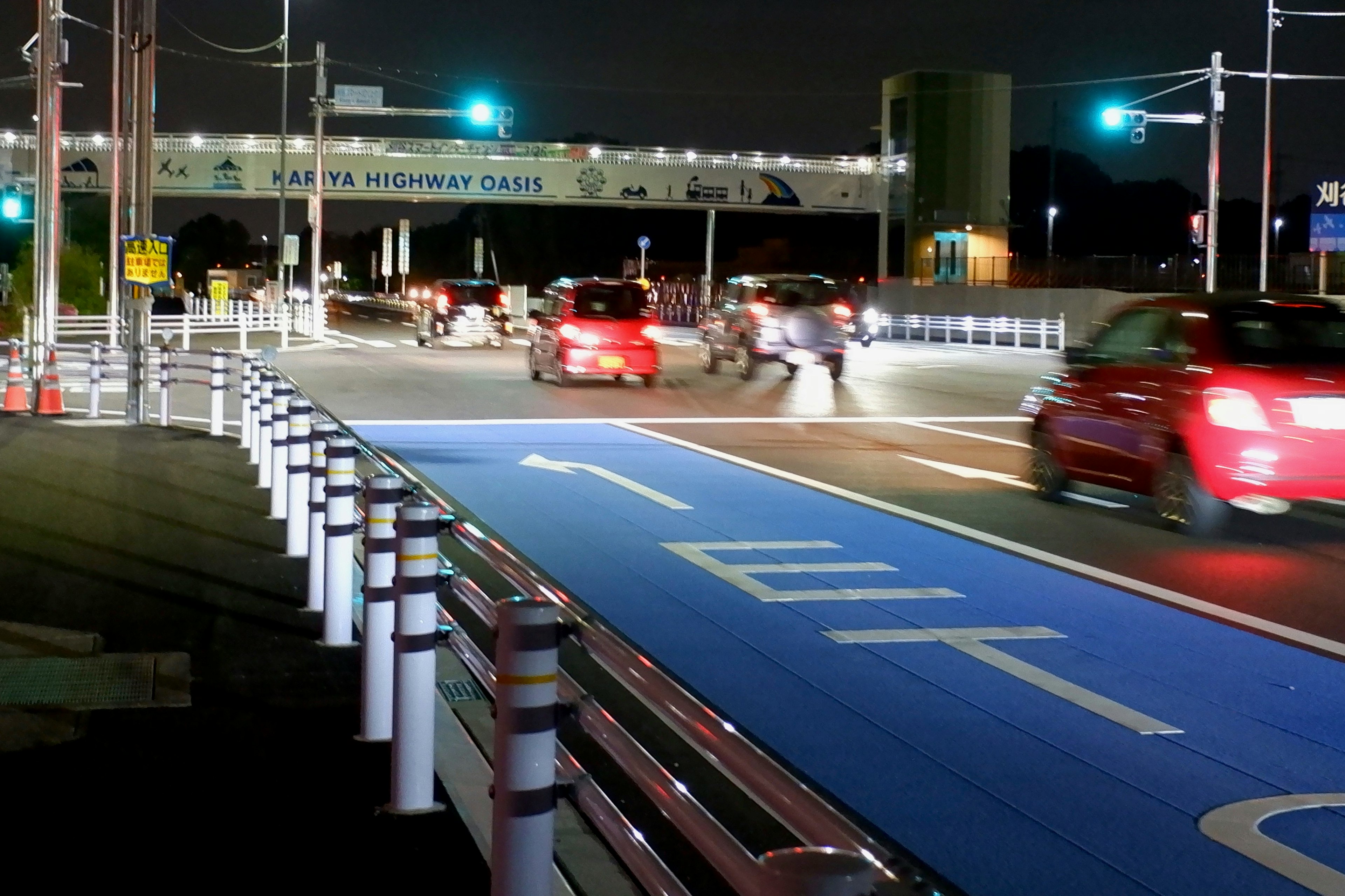 Incrocio notturno con una pista ciclabile blu e semafori