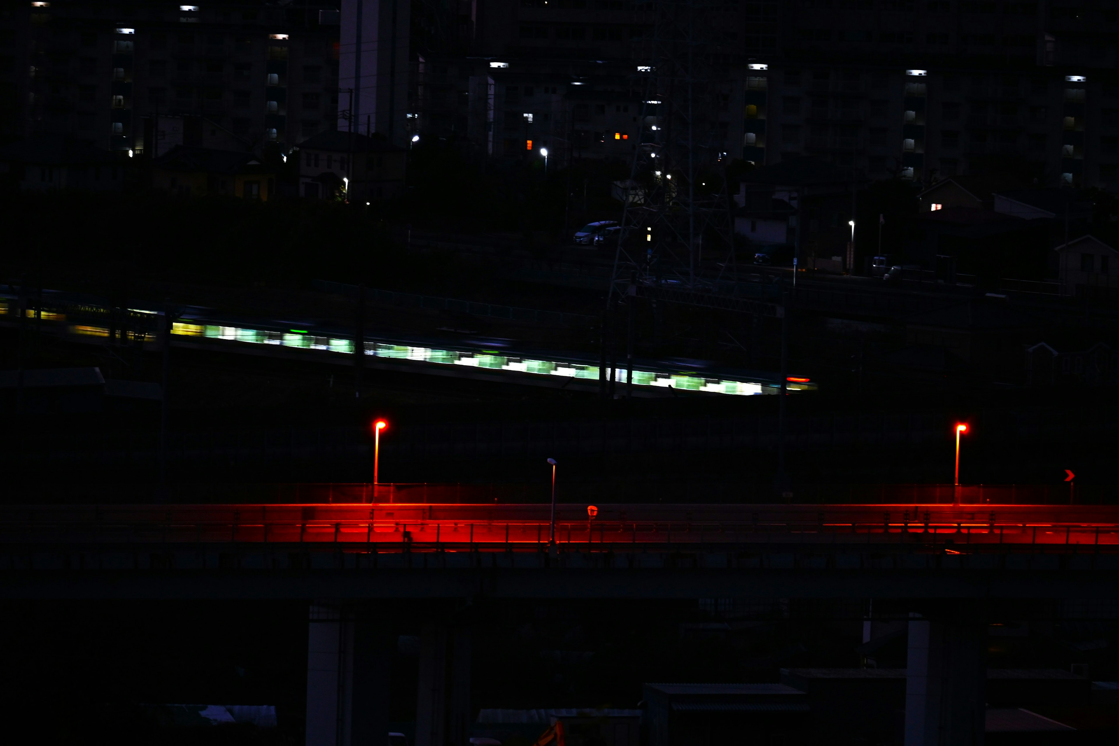 夜景の都市風景と赤い街灯が光る道路