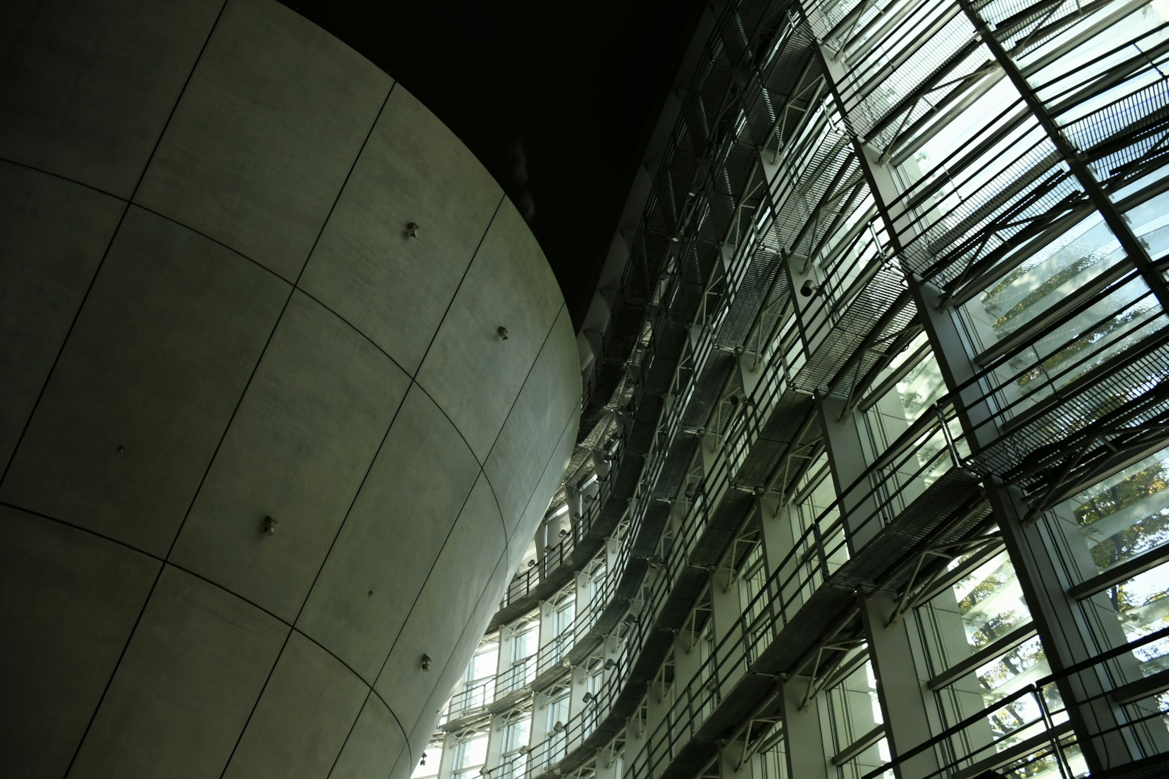 Structure architecturale moderne la nuit Façade en verre courbée Mur en béton