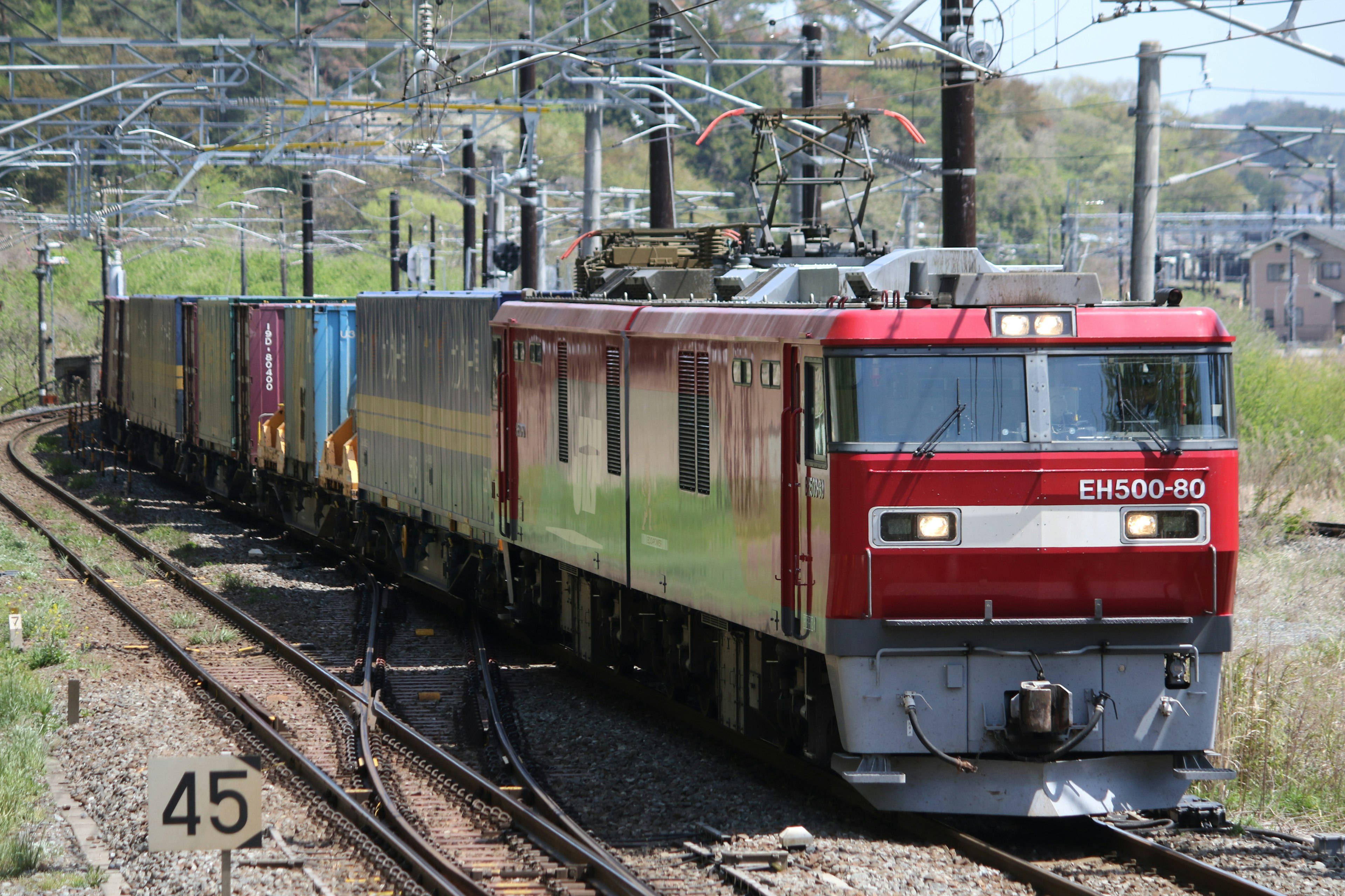 紅色電力機車在彎曲軌道上牽引貨運列車